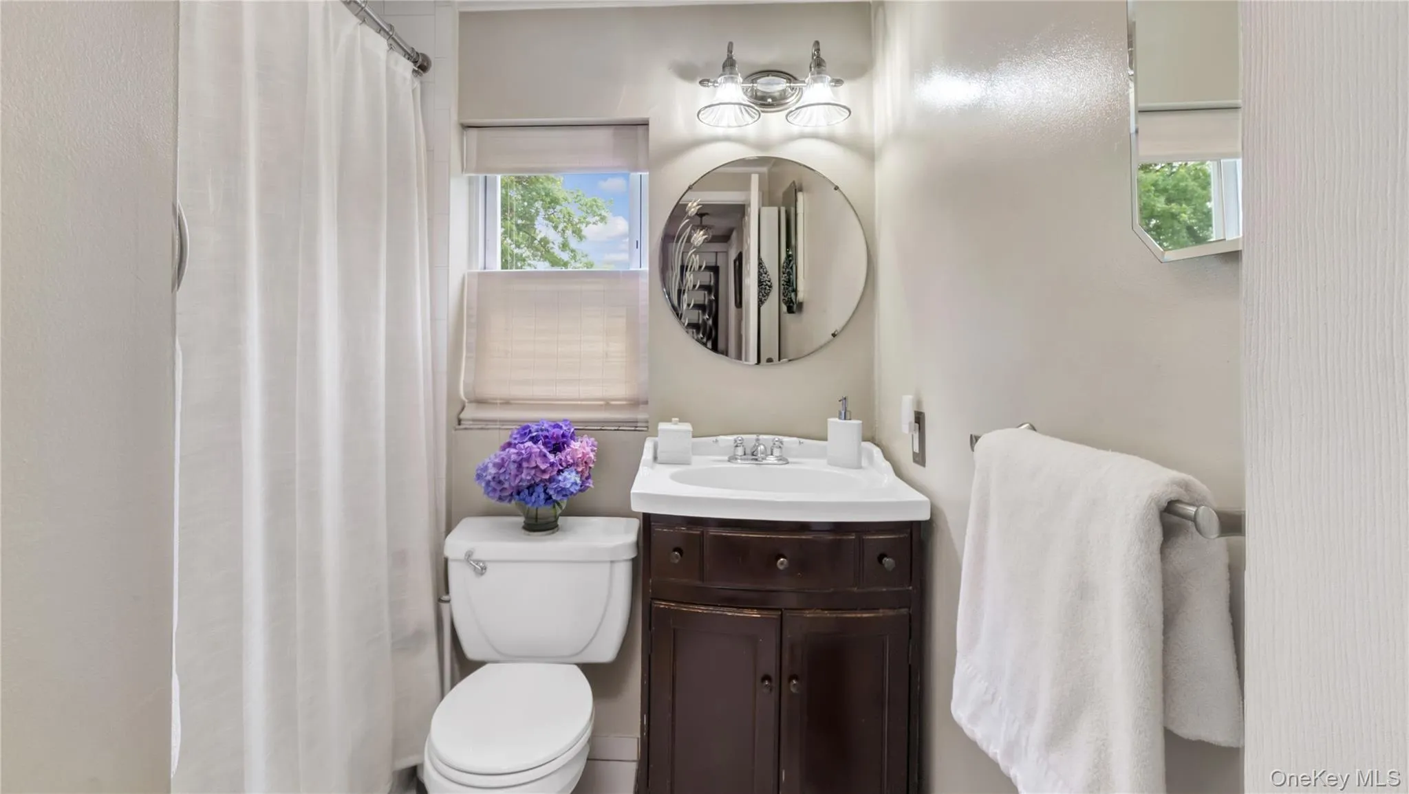 Full bathroom with vanity, a shower with curtain, and healthy amount of natural light Full bathroom with vanity, a shower with curtain, and healthy amount of natural light