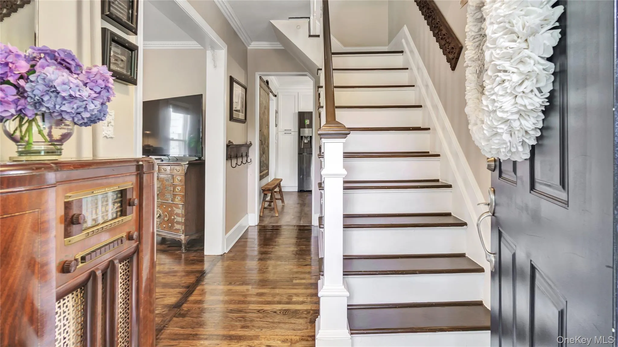 Stairway featuring ornamental molding and wood finished floors Stairway featuring ornamental molding and wood finished floors