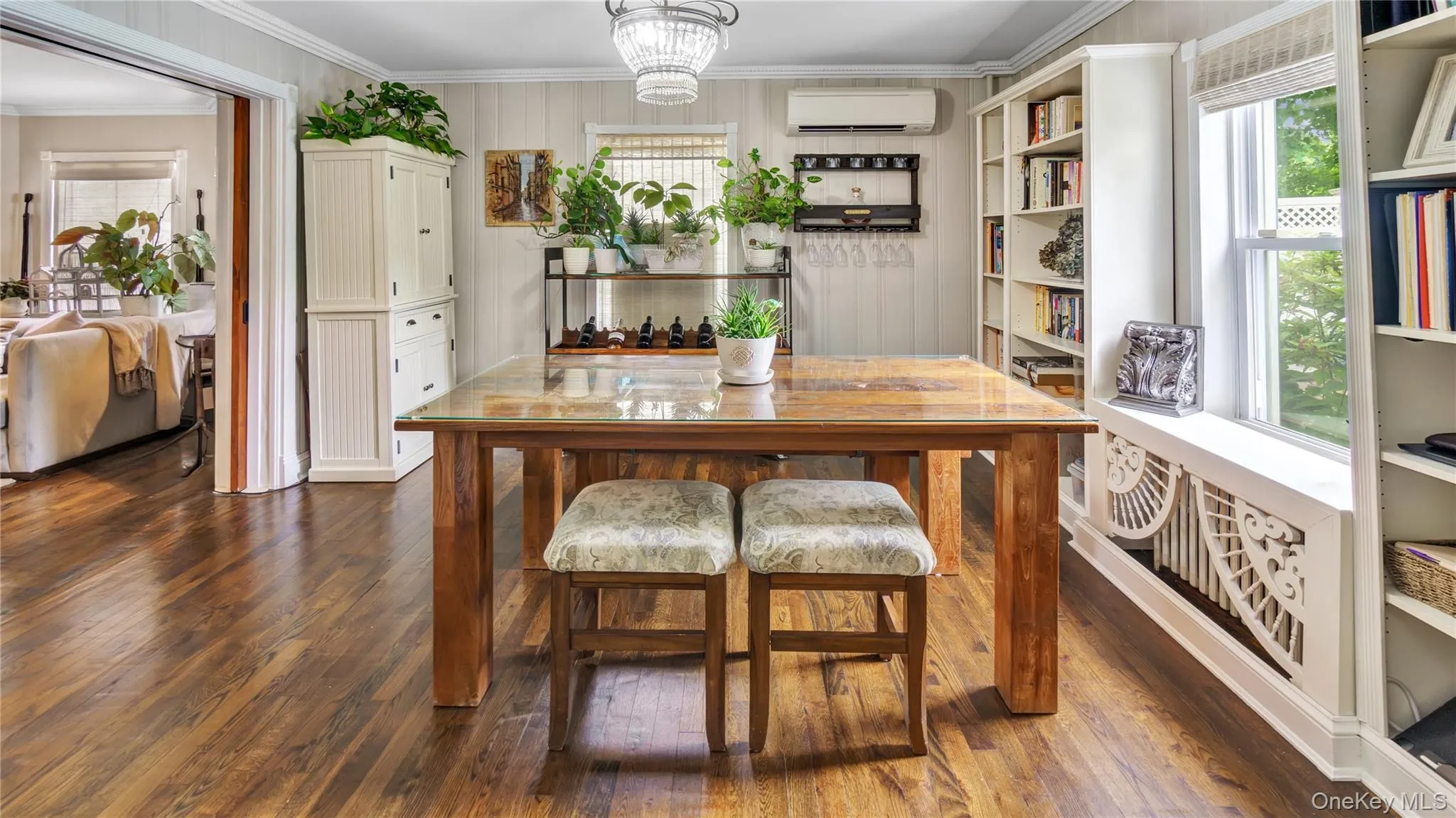 Dining area featuring crown molding, plenty of natural light, dark wood finished floors, and a chandelier Dining area featuring crown molding, plenty of natural light, dark wood finished floors, and a chandelier