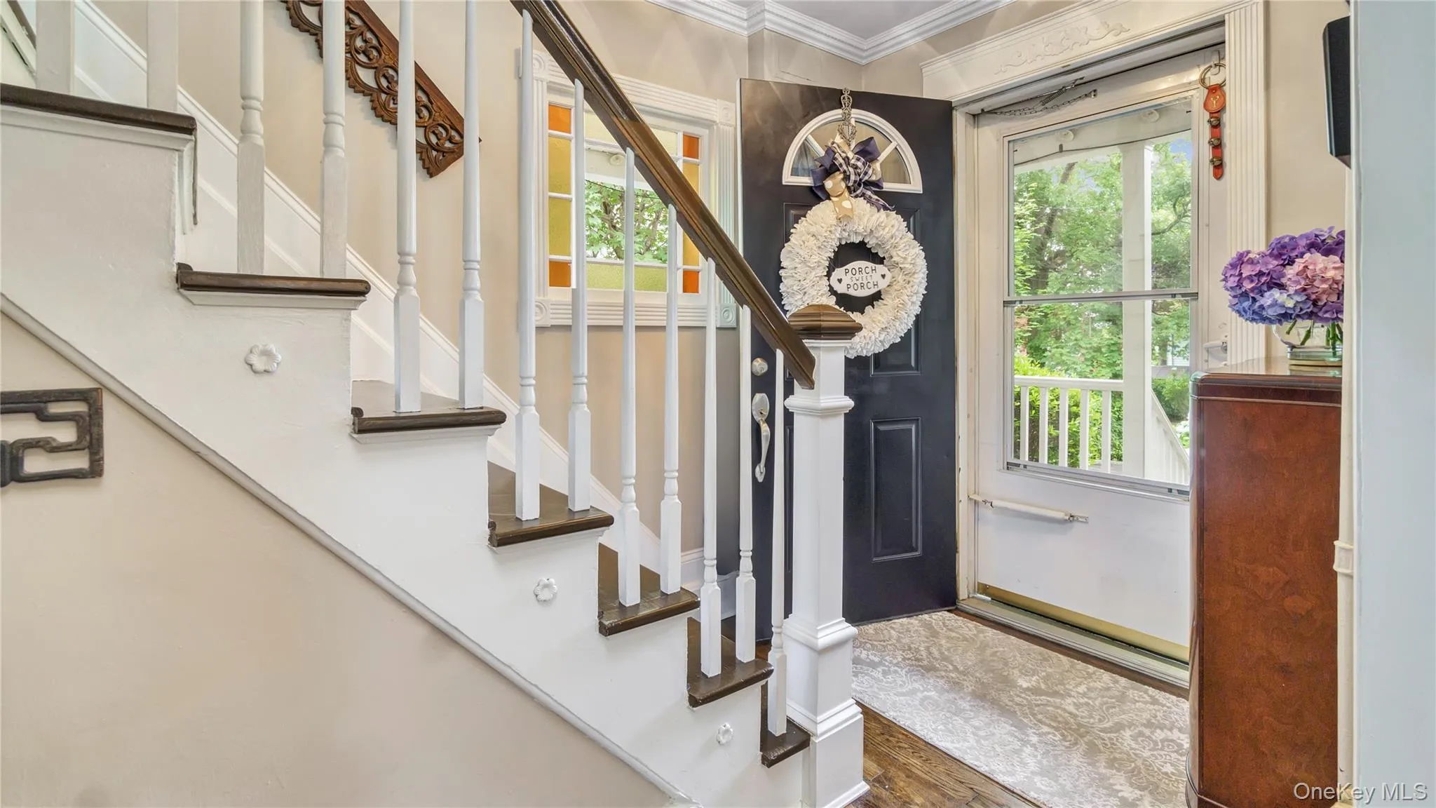 Foyer entrance with crown molding and wood finished floors Foyer entrance with crown molding and wood finished floors