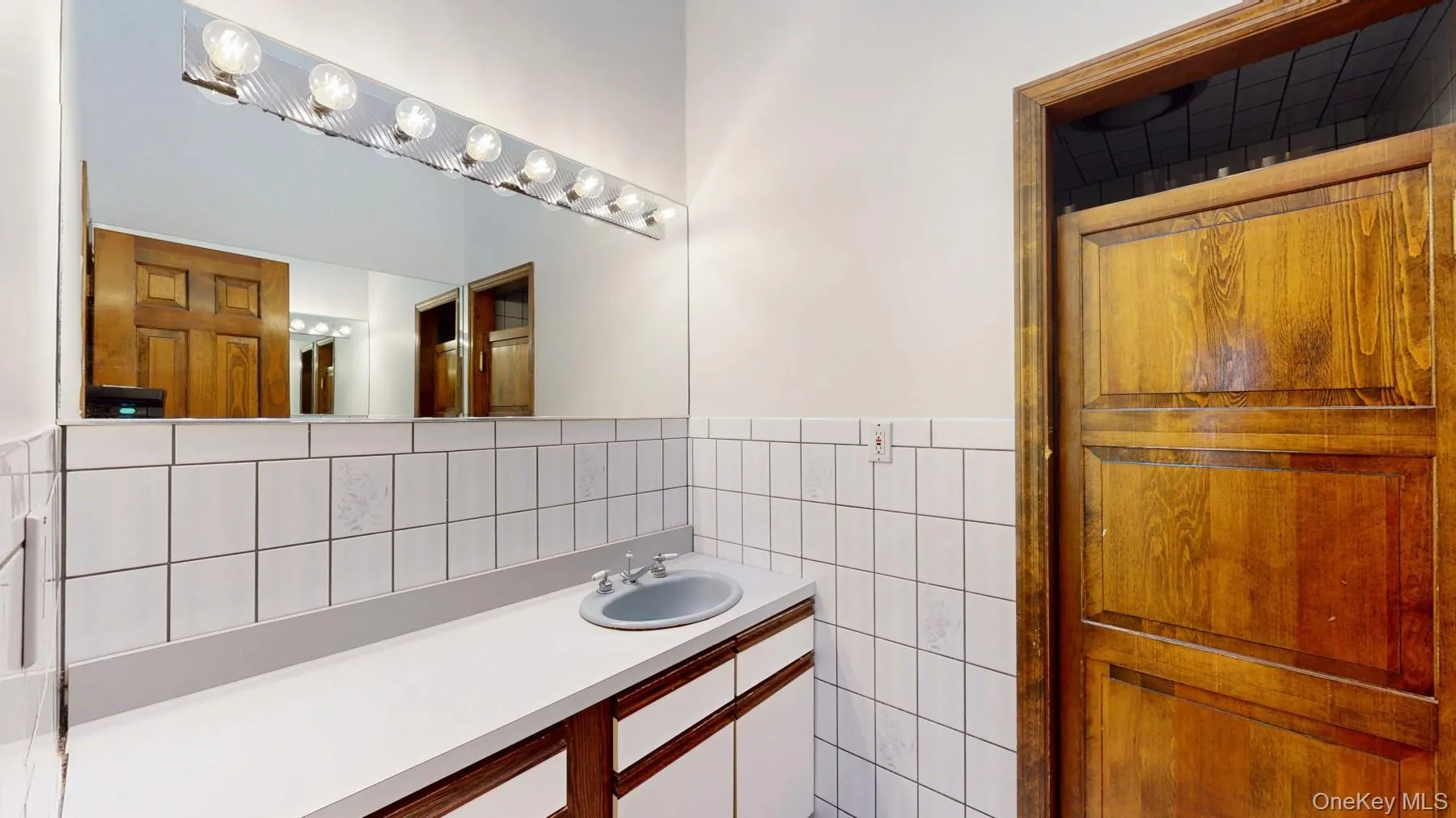 Bathroom featuring tile walls and vanity Bathroom featuring tile walls and vanity