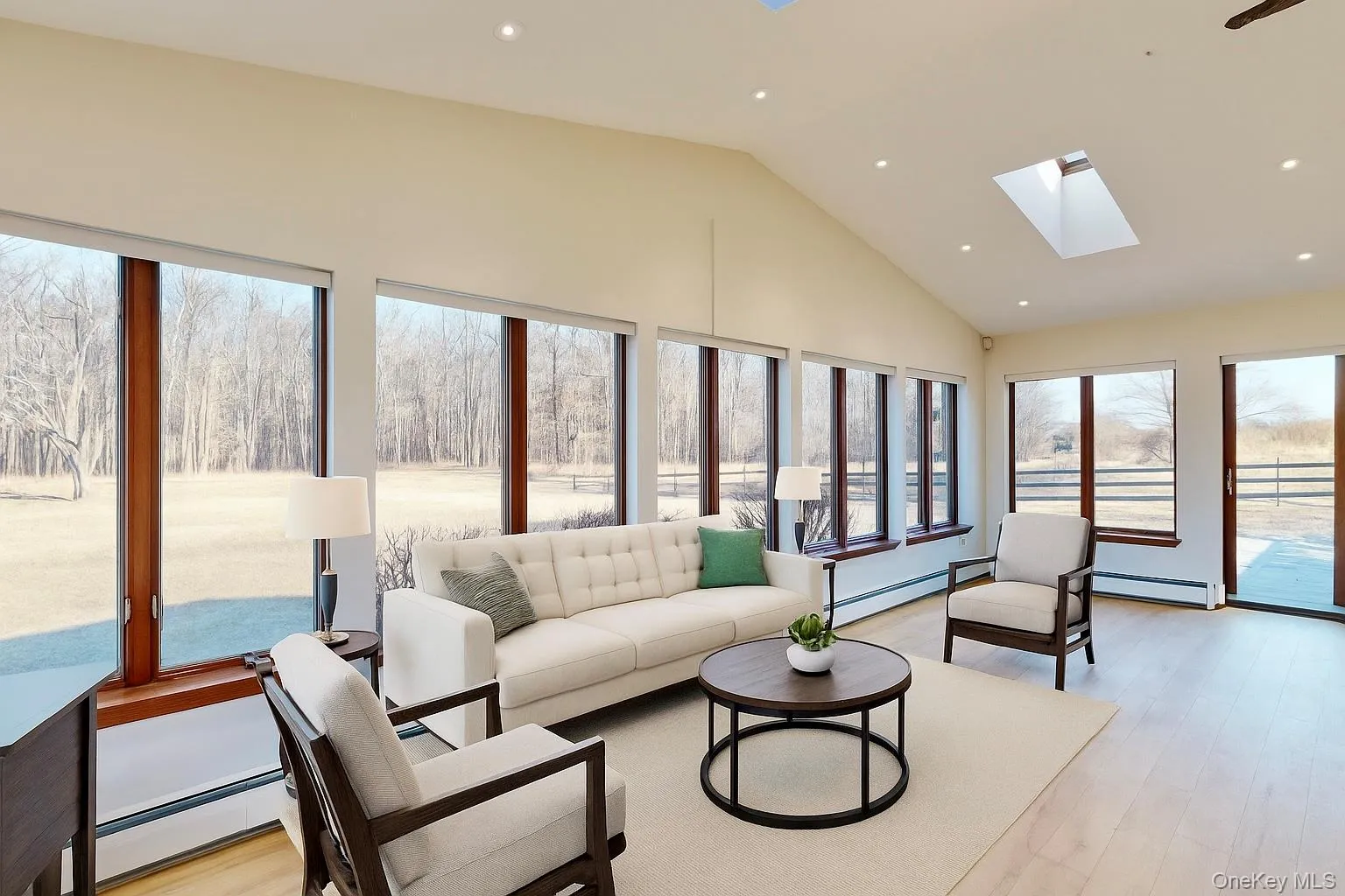 Sunroom with wood finished floors, a baseboard heating unit, recessed lighting, and high vaulted ceiling (virtually staged) Sunroom with wood finished floors, a baseboard heating unit, recessed lighting, and high vaulted ceiling (virtually staged)