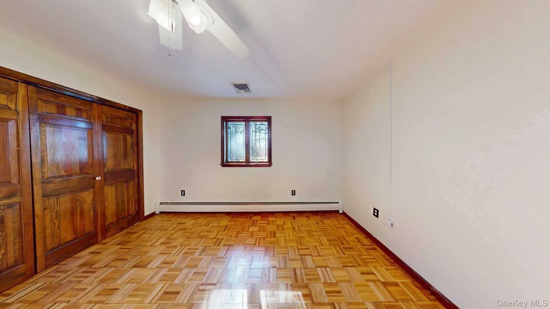 Unfurnished bedroom with a baseboard radiator, baseboards, visible vents, and a ceiling fan Unfurnished bedroom with a baseboard radiator, baseboards, visible vents, and a ceiling fan