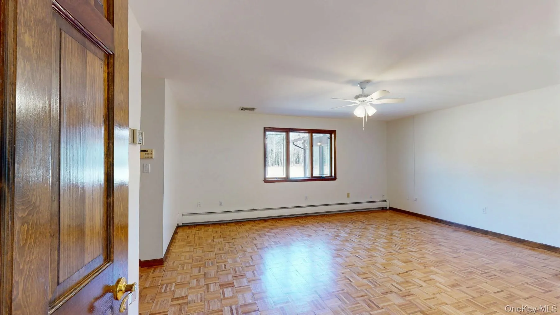 Spare room with a baseboard radiator, baseboards, visible vents, and a ceiling fan Spare room with a baseboard radiator, baseboards, visible vents, and a ceiling fan