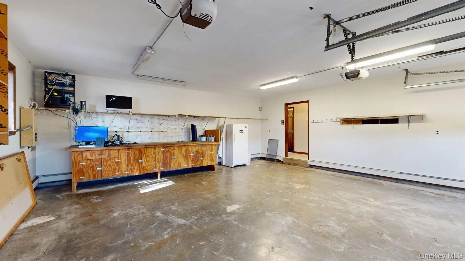 Garage featuring a garage door opener and baseboard heating Garage featuring a garage door opener and baseboard heating