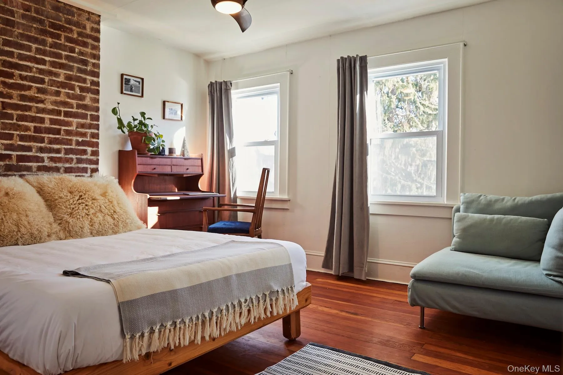 Bedroom featuring dark wood-style flooring and multiple windows Bedroom featuring dark wood-style flooring and multiple windows