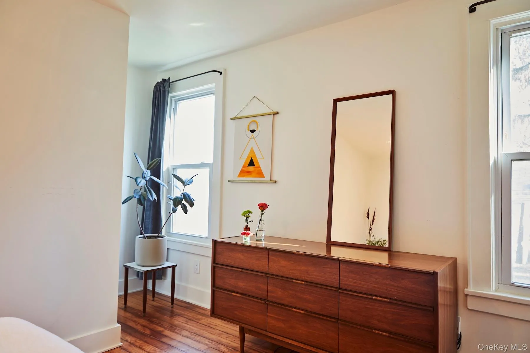 Bedroom featuring dark wood-style floors and baseboards Bedroom featuring dark wood-style floors and baseboards