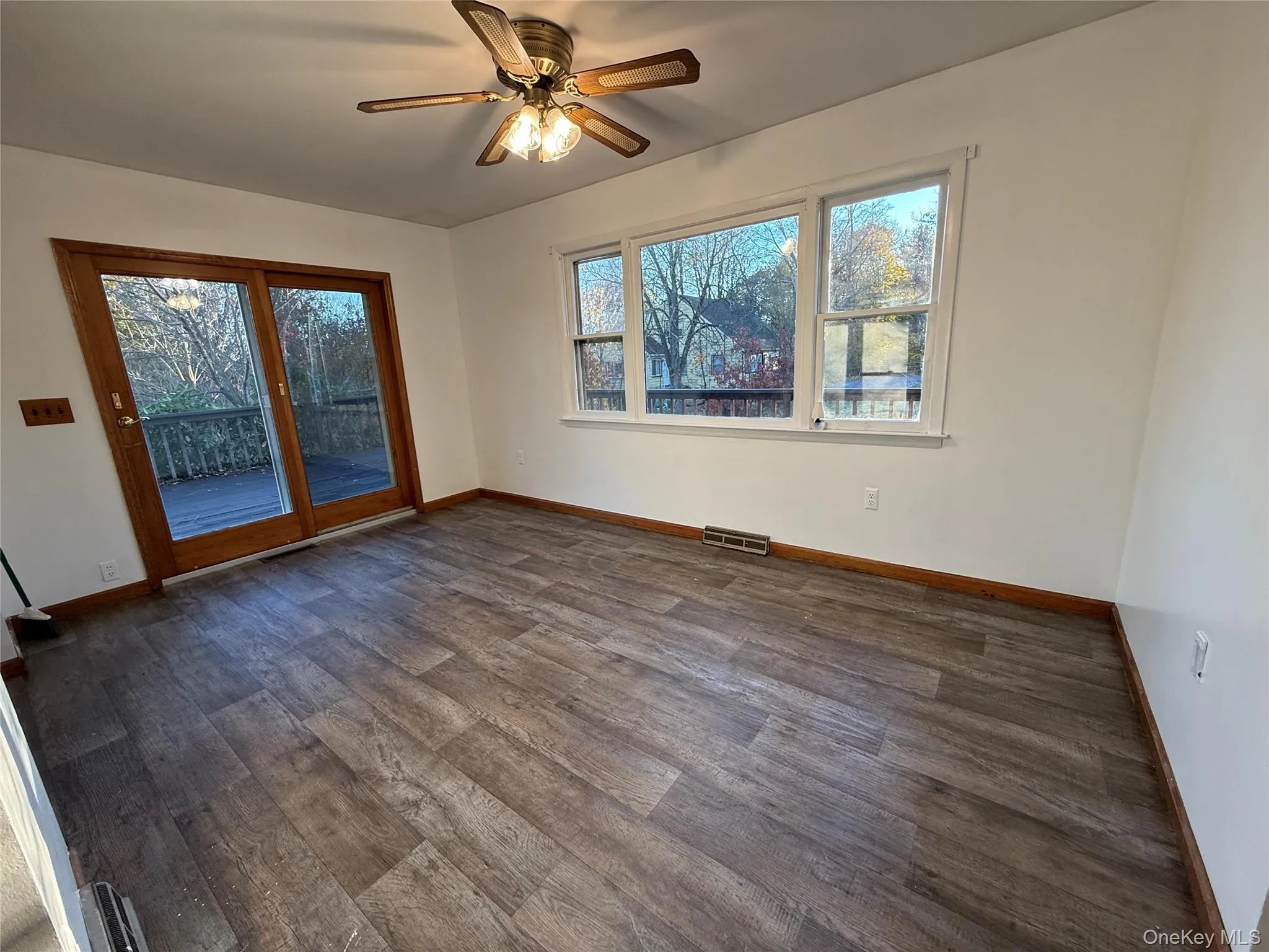 Spare room featuring ceiling fan and dark wood finished floors Spare room featuring ceiling fan and dark wood finished floors