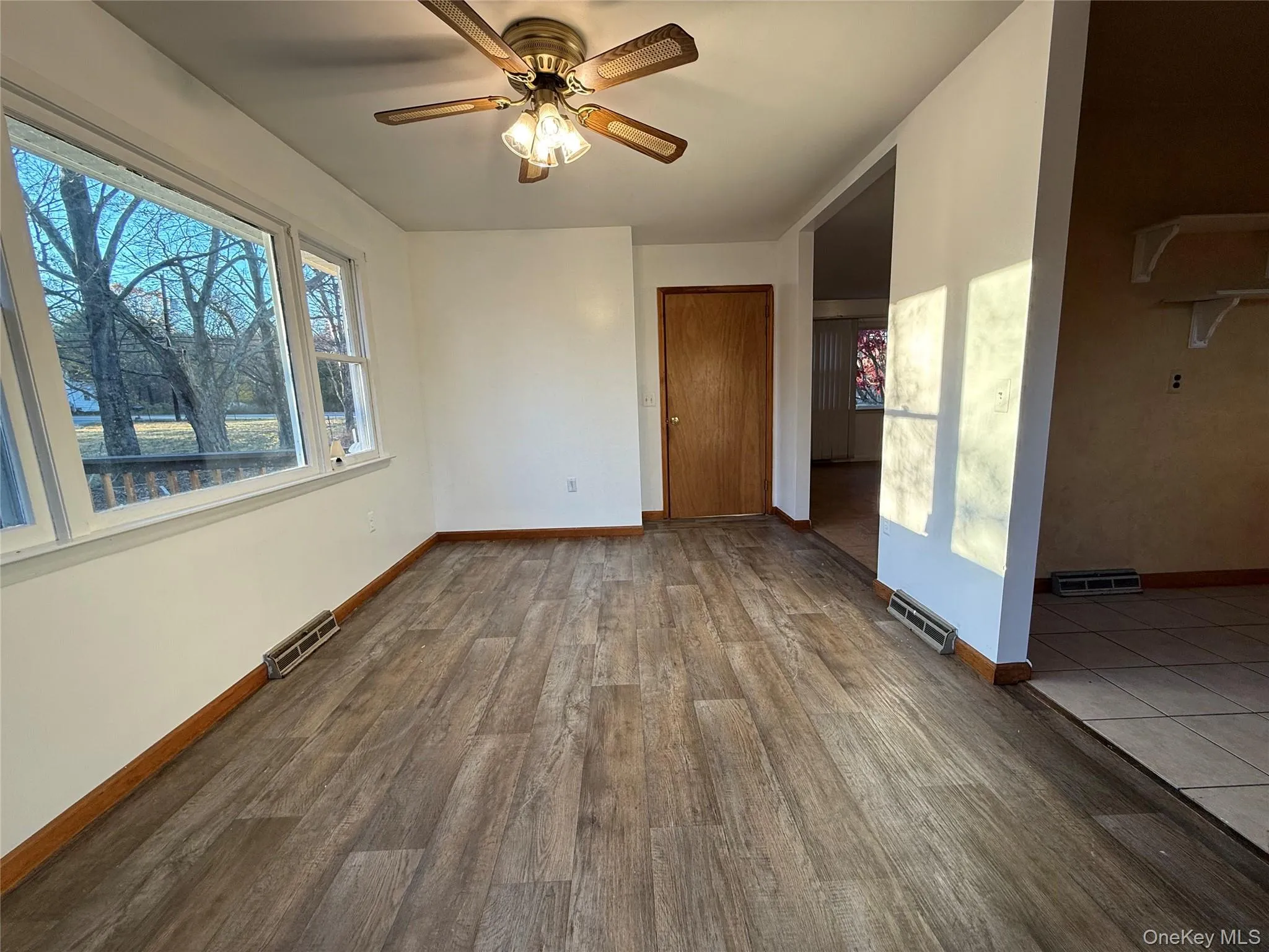 Unfurnished room with dark wood-style flooring and a ceiling fan Unfurnished room with dark wood-style flooring and a ceiling fan