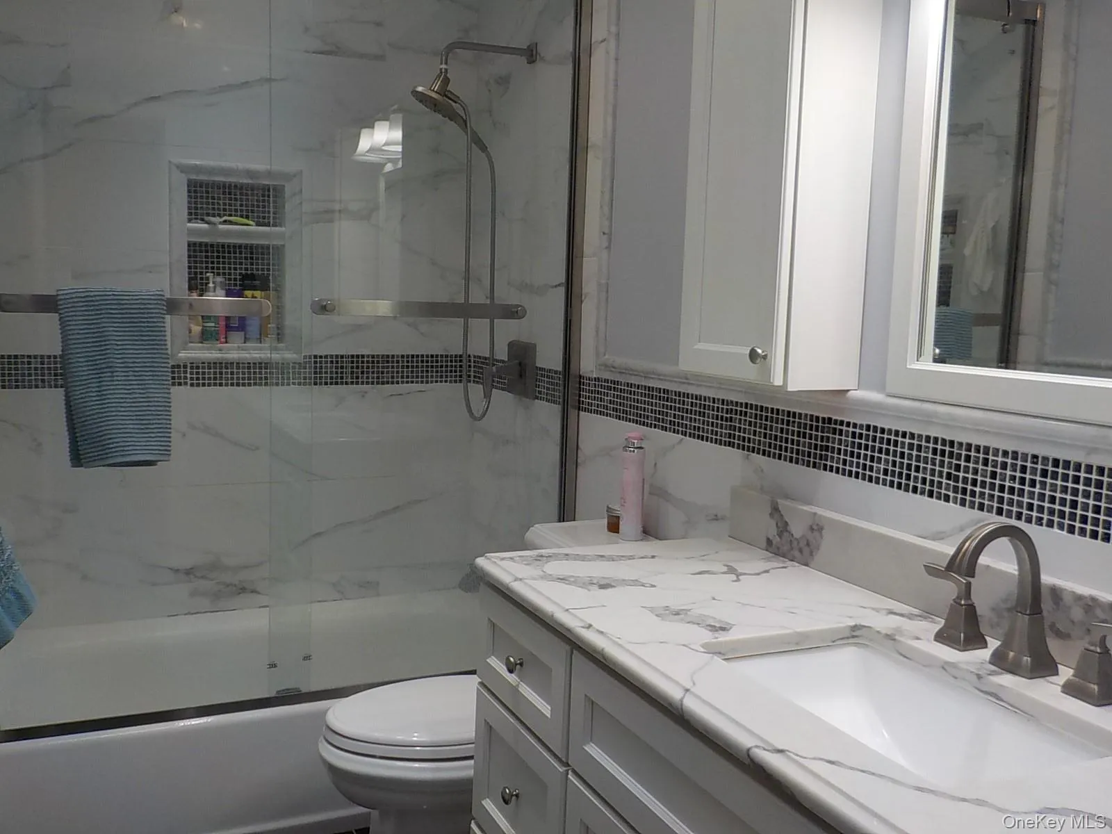 Bathroom featuring vanity, decorative backsplash, and combined bath / shower with glass door Bathroom featuring vanity, decorative backsplash, and combined bath / shower with glass door