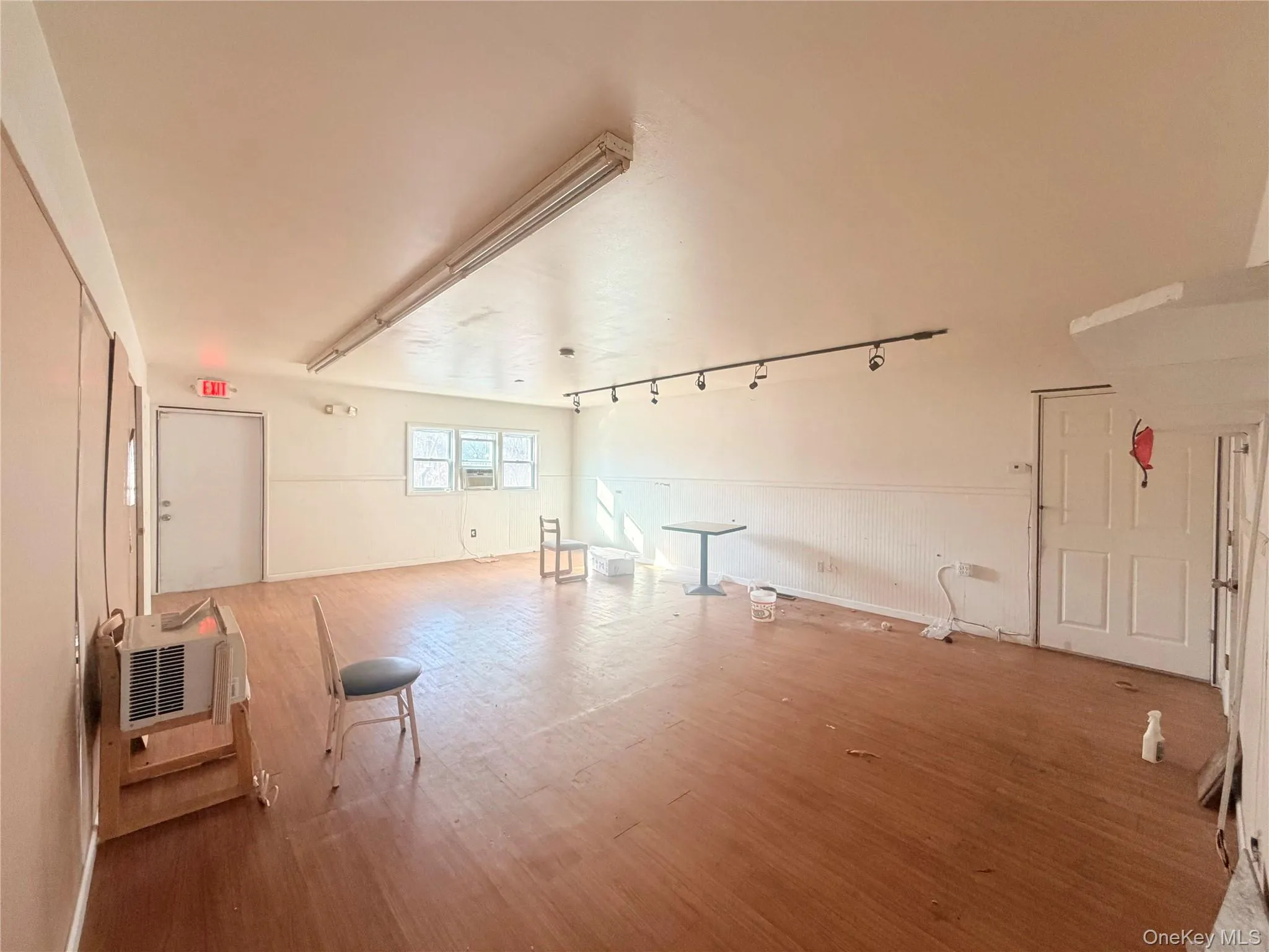 Unfurnished living room with wood finished floors and rail lighting Unfurnished living room with wood finished floors and rail lighting