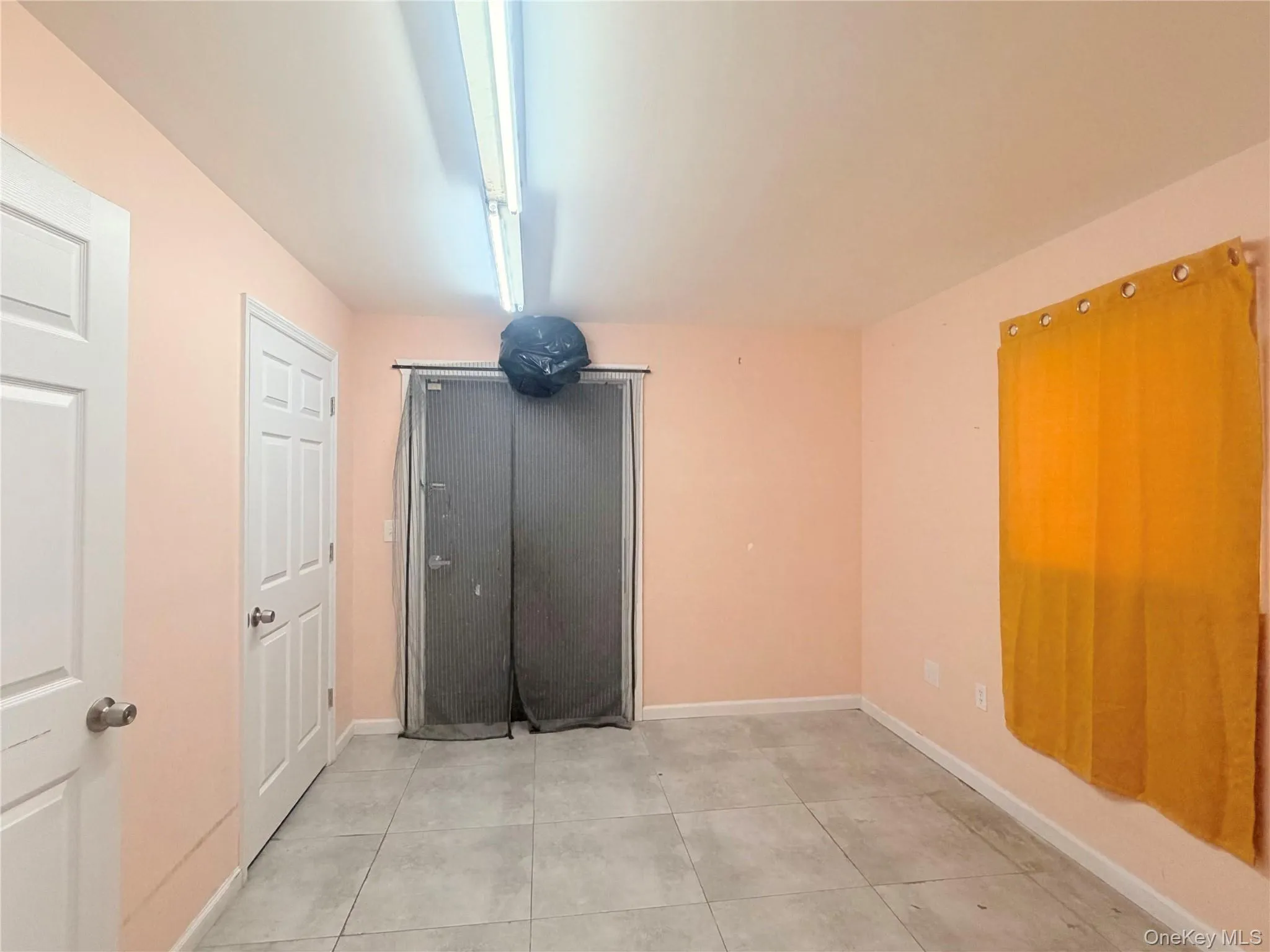 Unfurnished bedroom featuring light tile patterned floors and baseboards Unfurnished bedroom featuring light tile patterned floors and baseboards