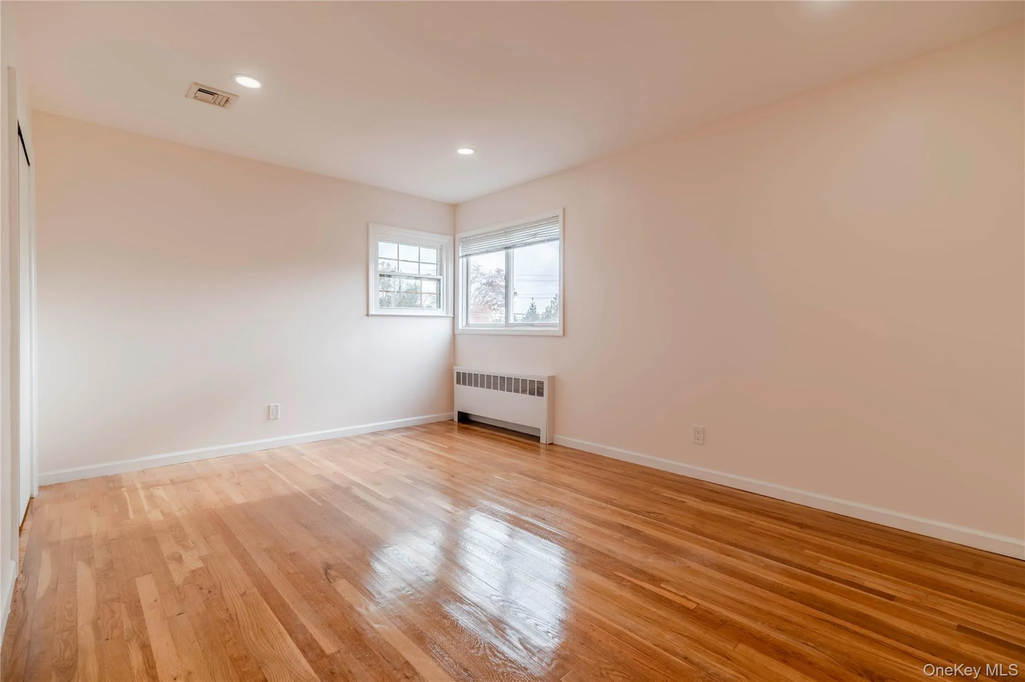Unfurnished room with radiator heating unit, recessed lighting, and light wood-style flooring Unfurnished room with radiator heating unit, recessed lighting, and light wood-style flooring
