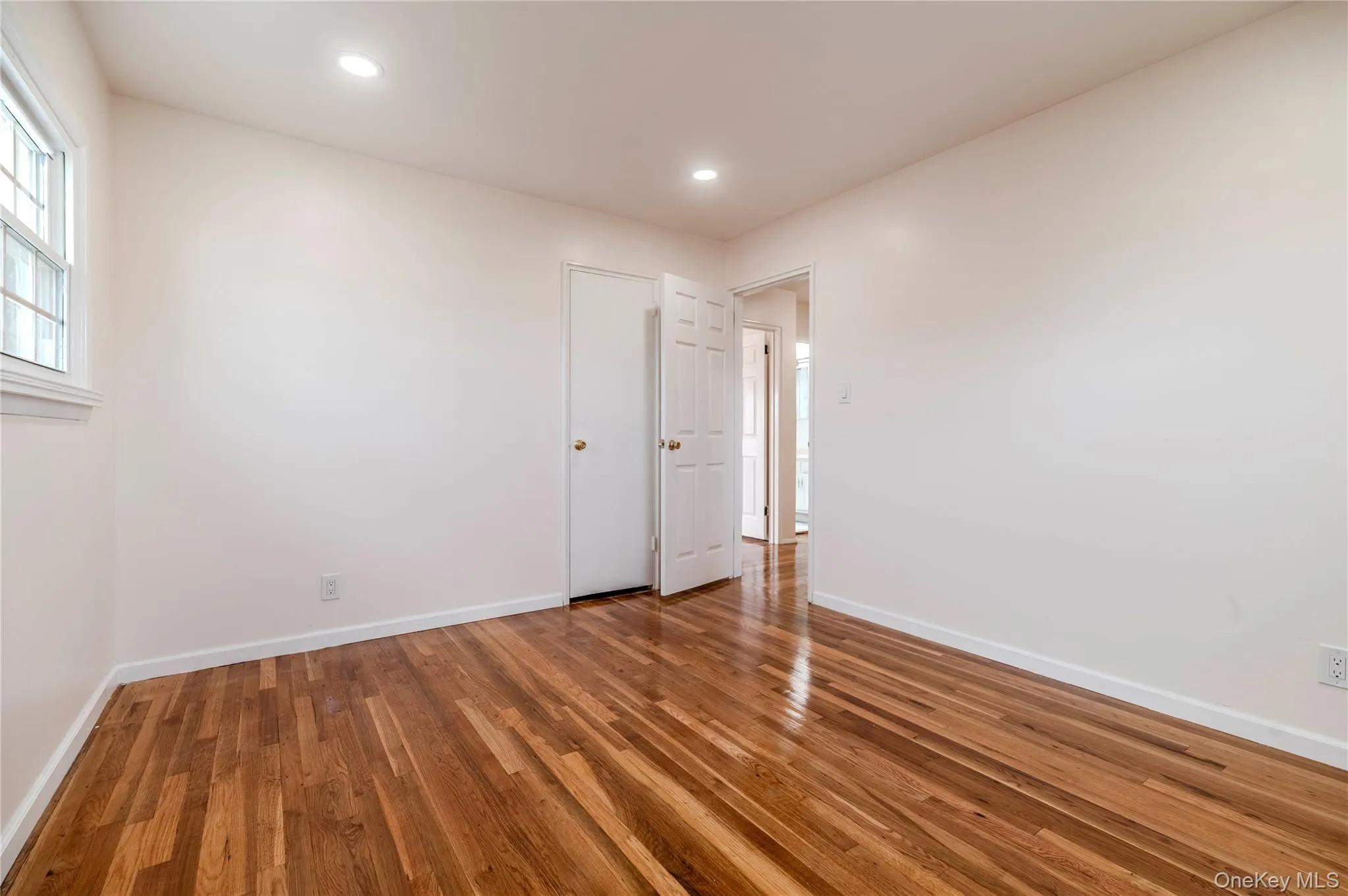 Empty room with wood finished floors and recessed lighting Empty room with wood finished floors and recessed lighting