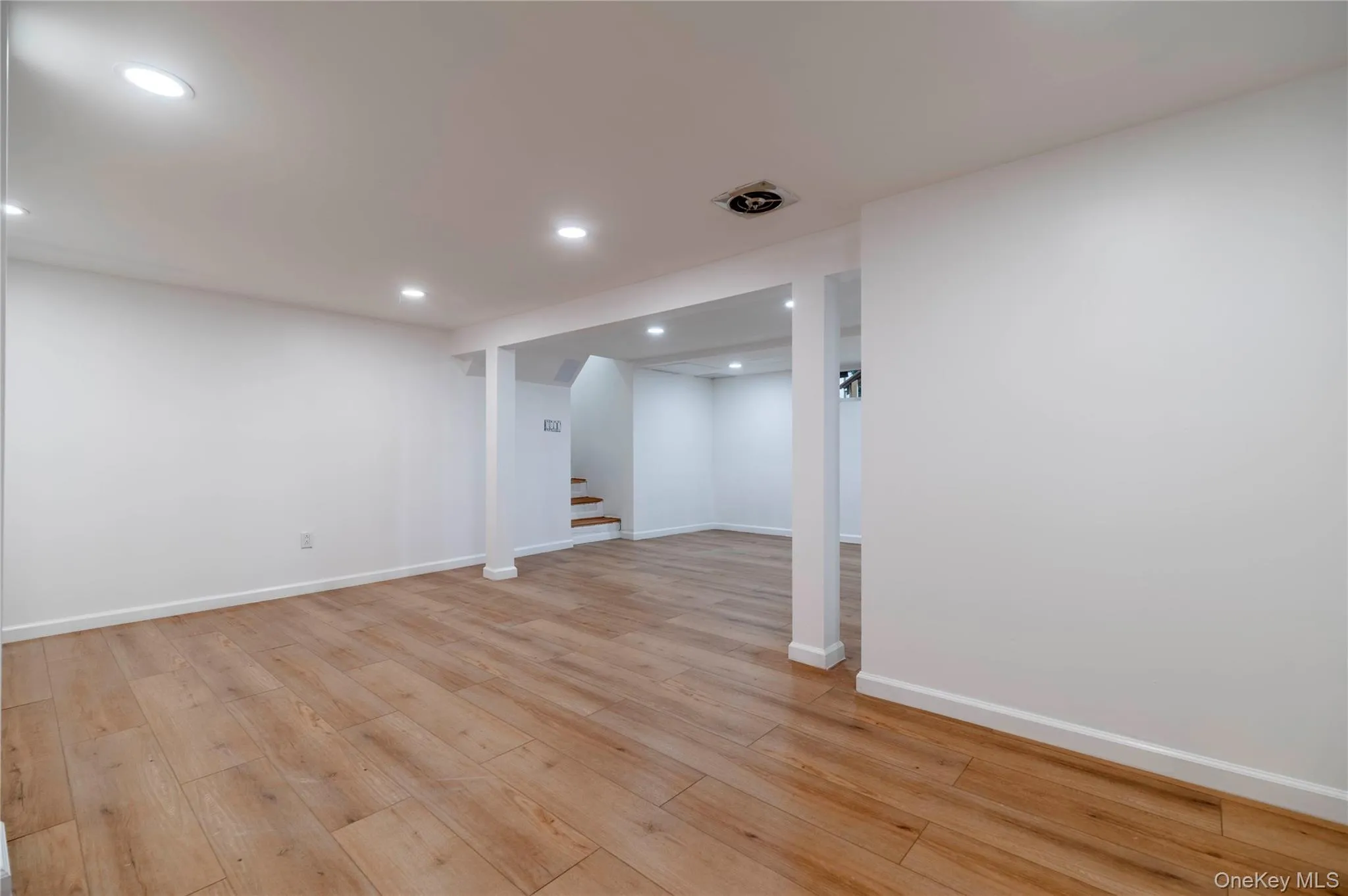 Finished basement featuring stairway, light wood-type flooring, and recessed lighting Finished basement featuring stairway, light wood-type flooring, and recessed lighting