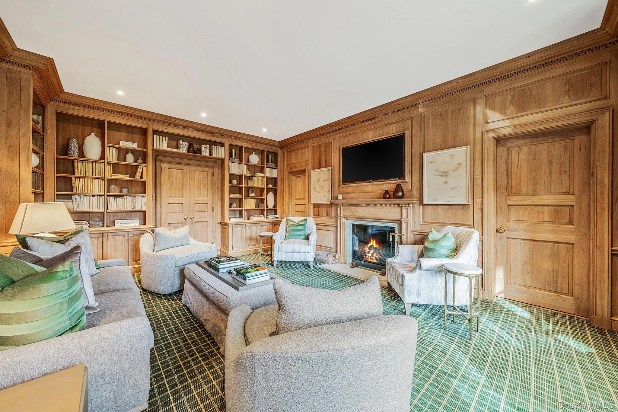 Library with built in shelves, a glass covered fireplace Library with built in shelves, a glass covered fireplace