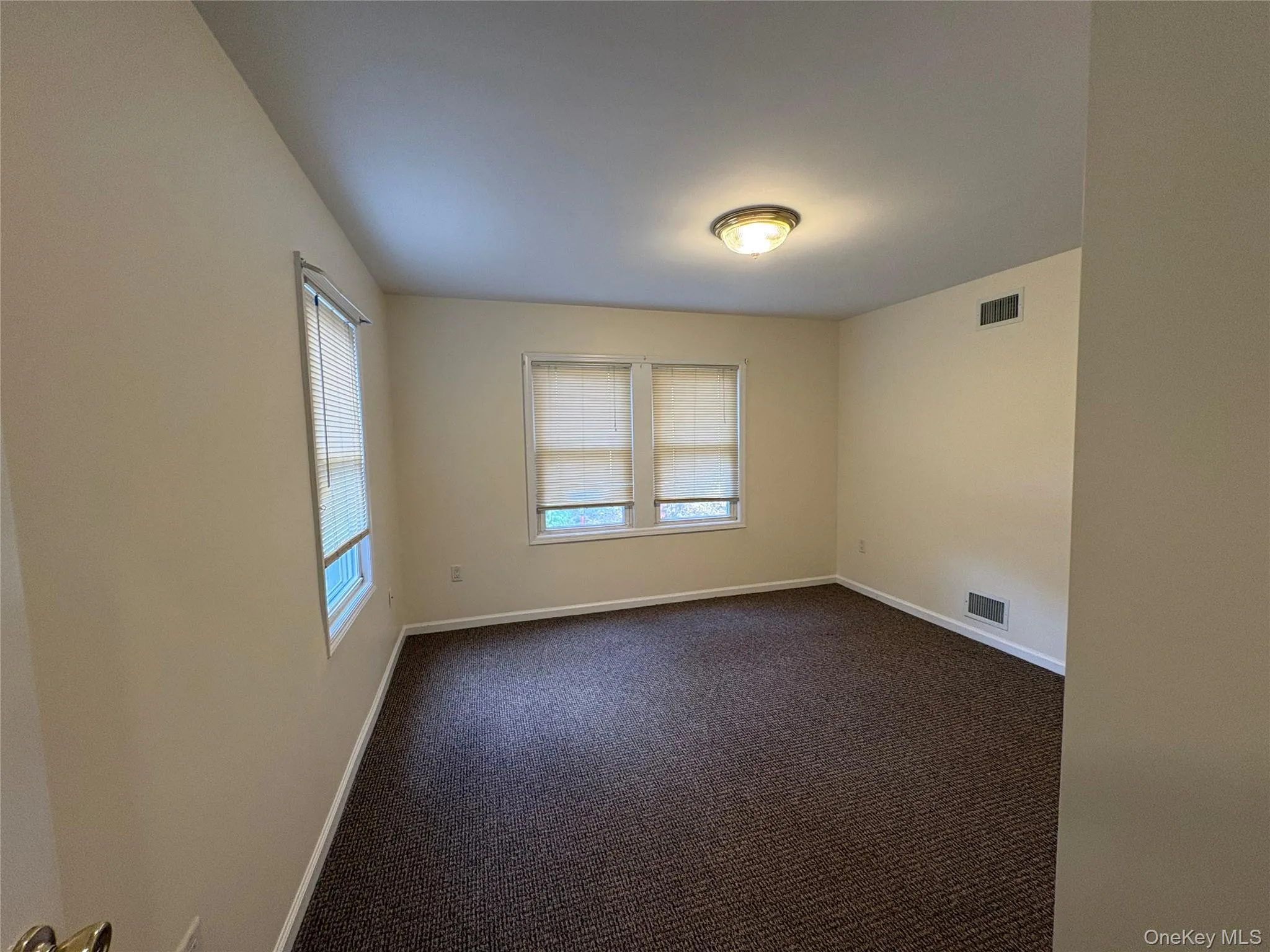 Spare room with dark carpet and baseboards Spare room with dark carpet and baseboards