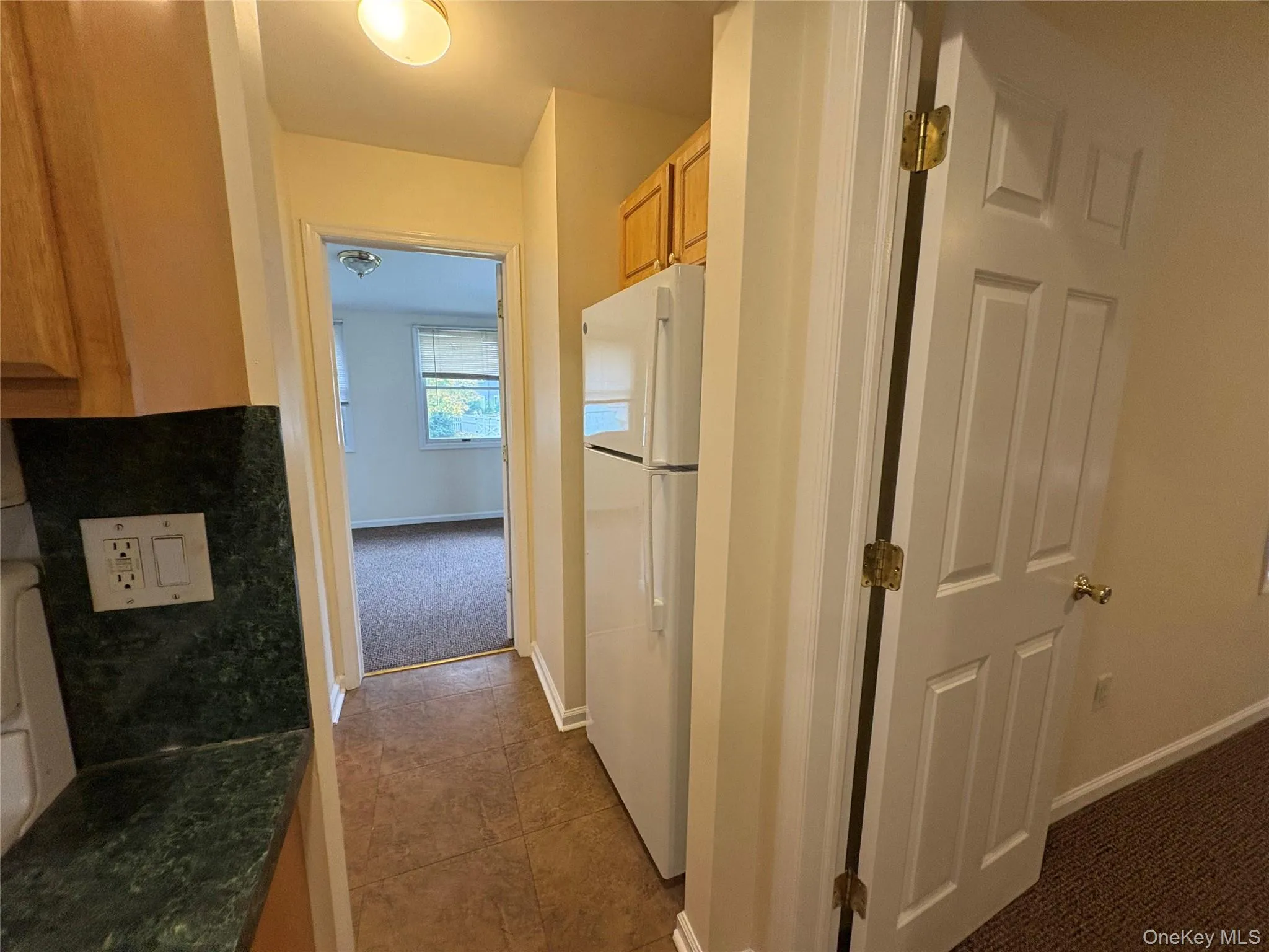 Hall with dark carpet and dark tile patterned floors Hall with dark carpet and dark tile patterned floors