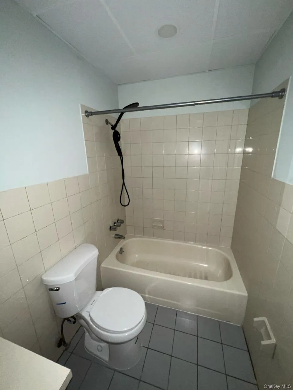 Full bath with tile patterned floors, tile walls, shower / bath combination, and vanity Full bath with tile patterned floors, tile walls, shower / bath combination, and vanity