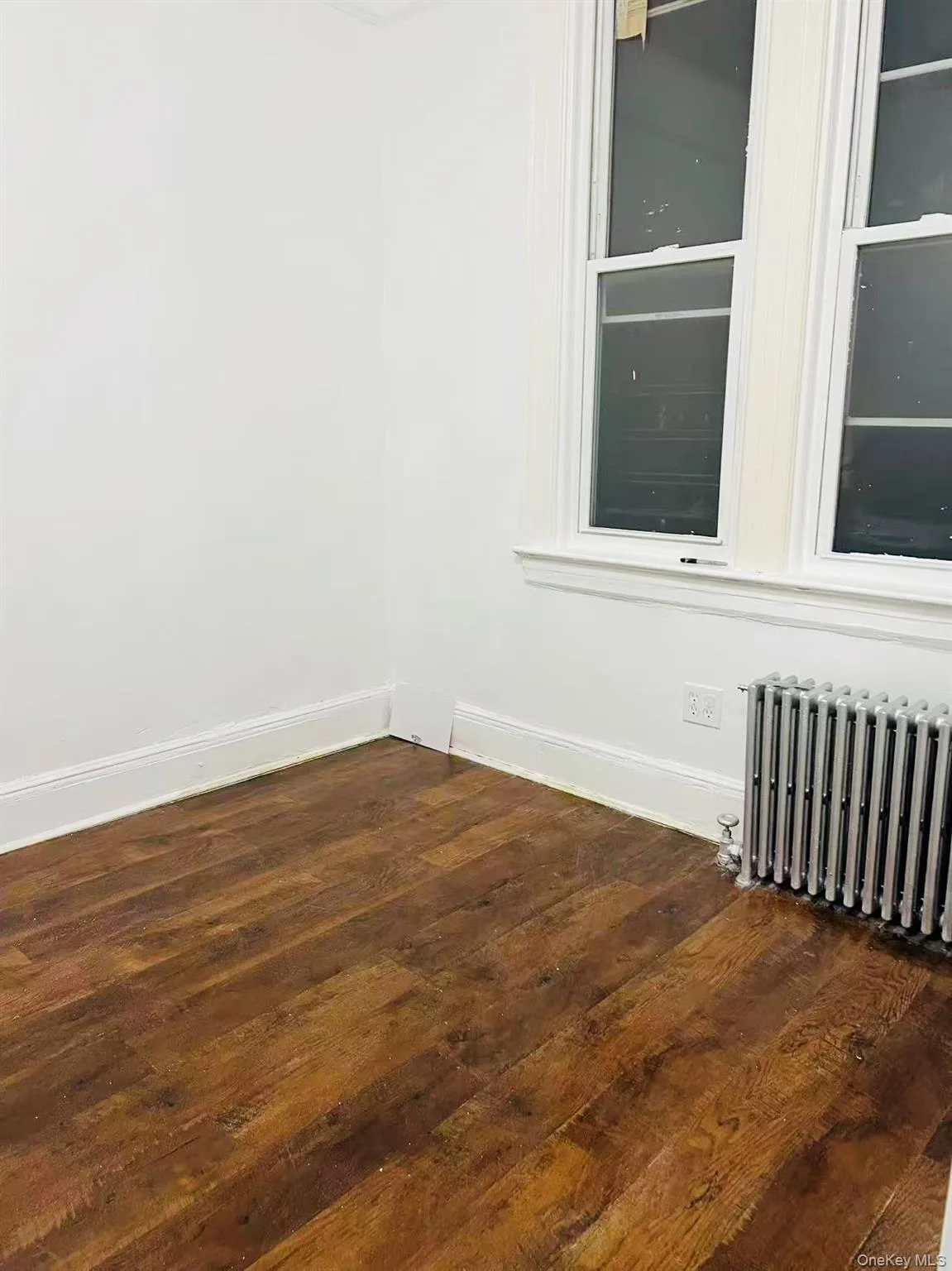 Empty room with dark wood finished floors and radiator Empty room with dark wood finished floors and radiator