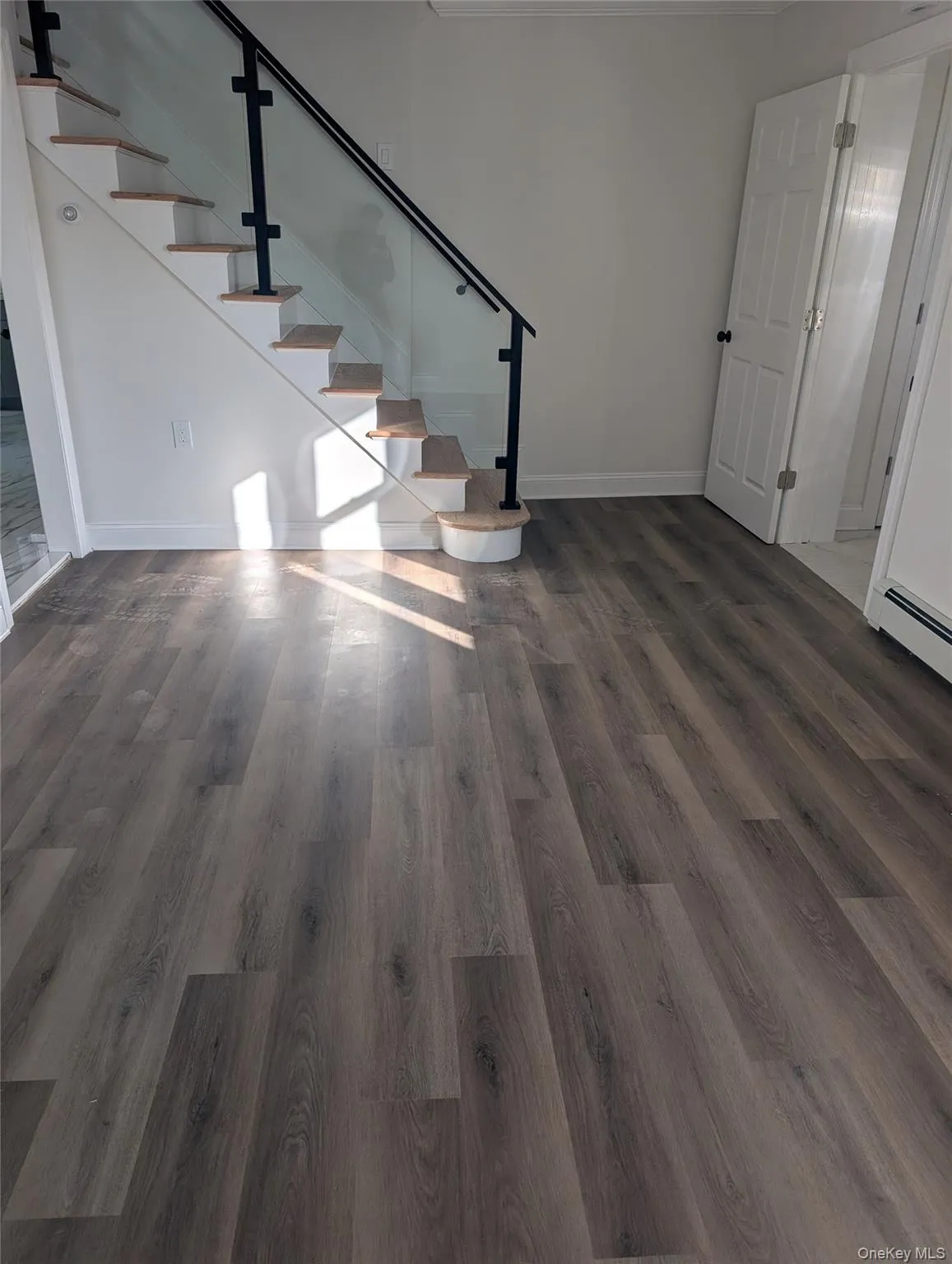 Stairway featuring wood finished floors and a baseboard heating unit Stairway featuring wood finished floors and a baseboard heating unit