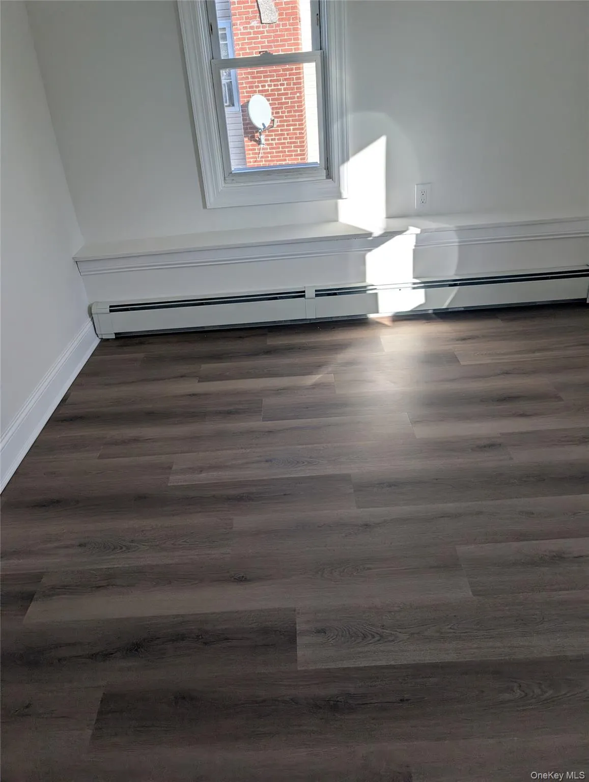 Detailed view of wood finished floors and a baseboard radiator Detailed view of wood finished floors and a baseboard radiator