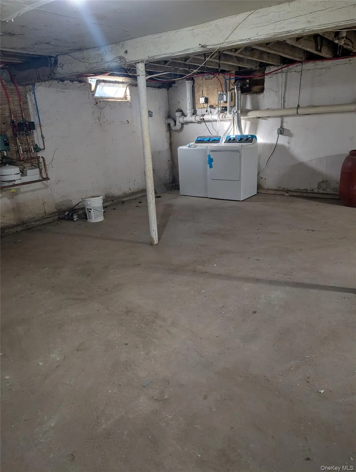 Below grade area with washer and clothes dryer and oil tank Below grade area with washer and clothes dryer and oil tank