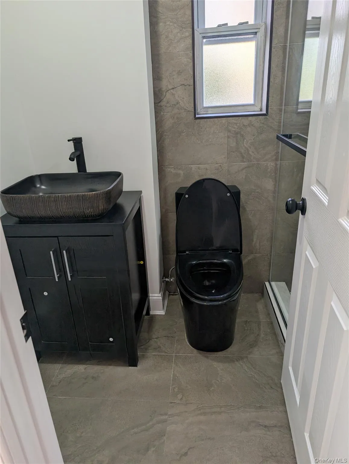 Bathroom with vanity, a baseboard radiator, and a stall shower Bathroom with vanity, a baseboard radiator, and a stall shower