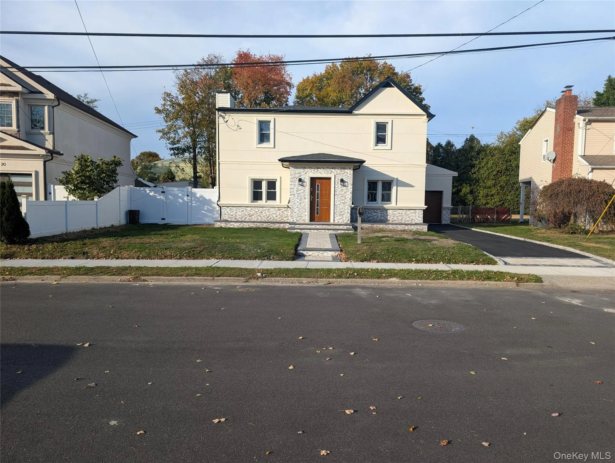 Traditional-style house featuring stone siding, a chimney, and driveway Traditional-style house featuring stone siding, a chimney, and driveway