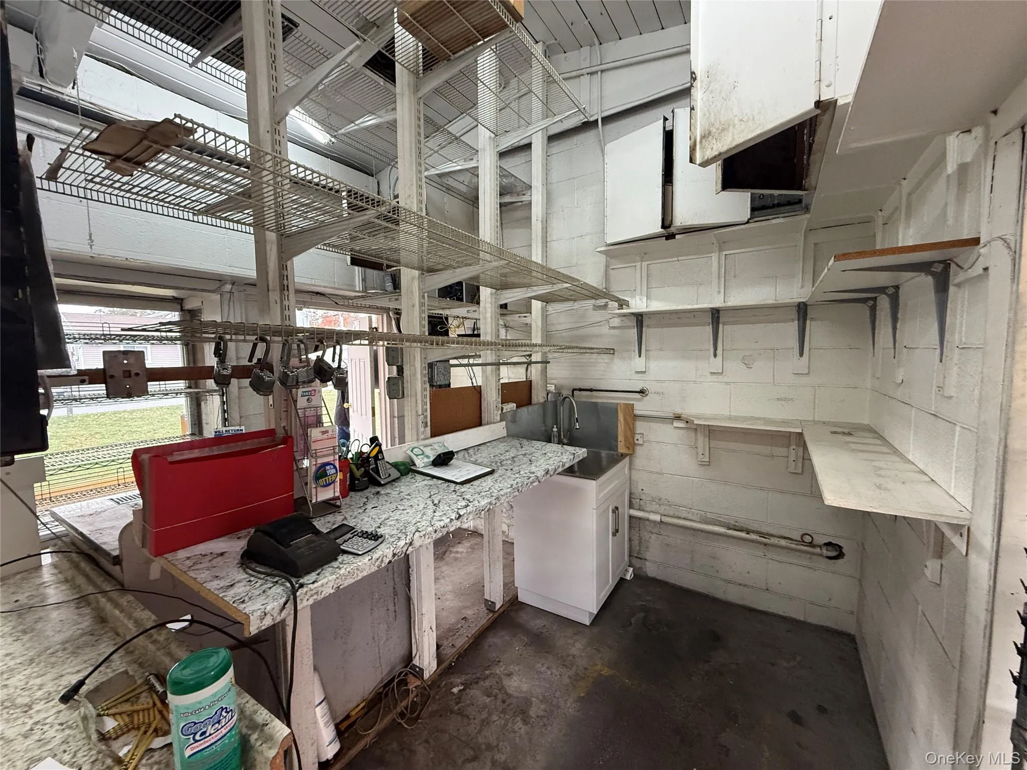 Kitchen featuring unfinished concrete floors and concrete block wall Kitchen featuring unfinished concrete floors and concrete block wall