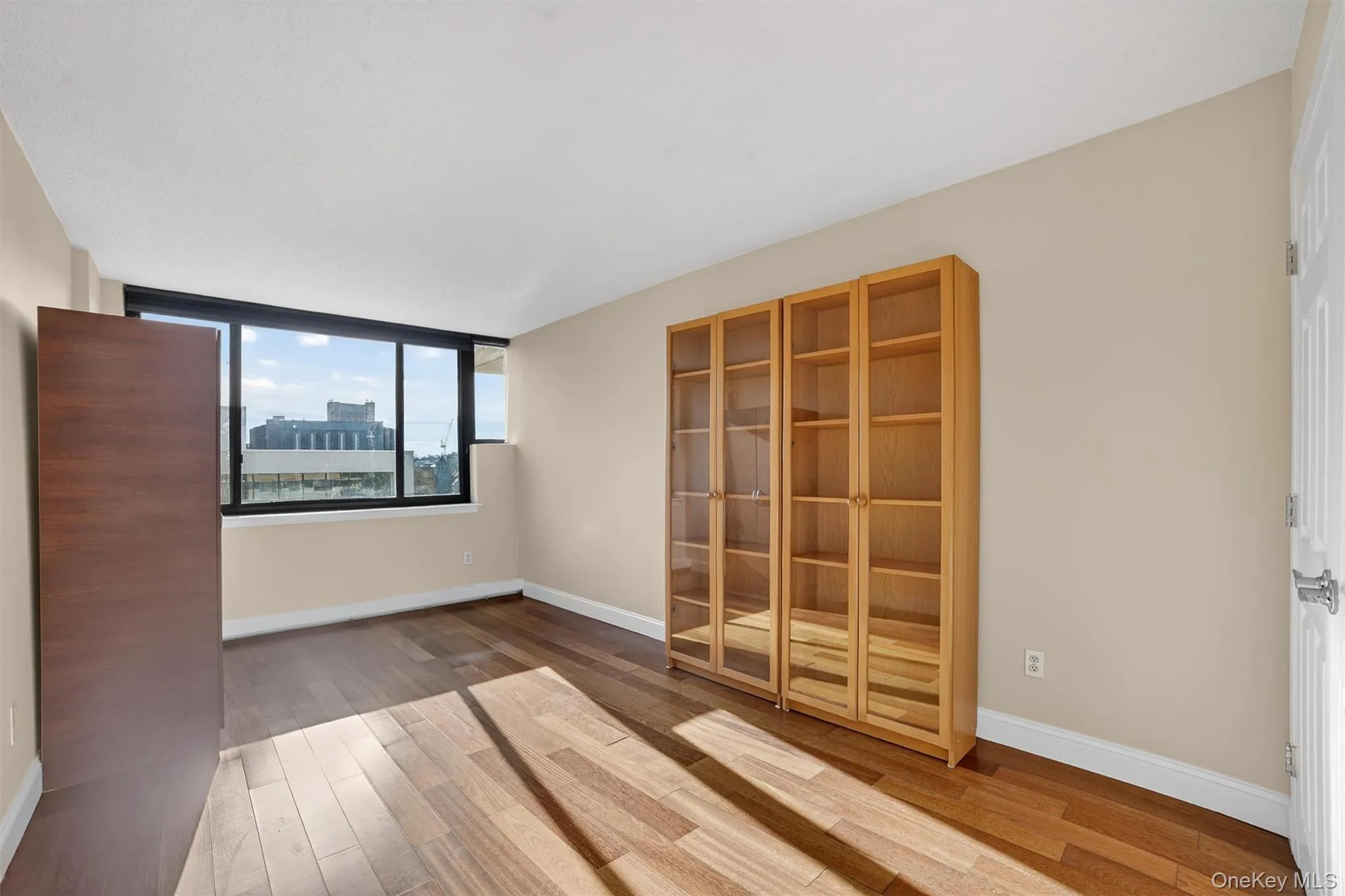 Spare room with light wood-style floors and baseboards Spare room with light wood-style floors and baseboards