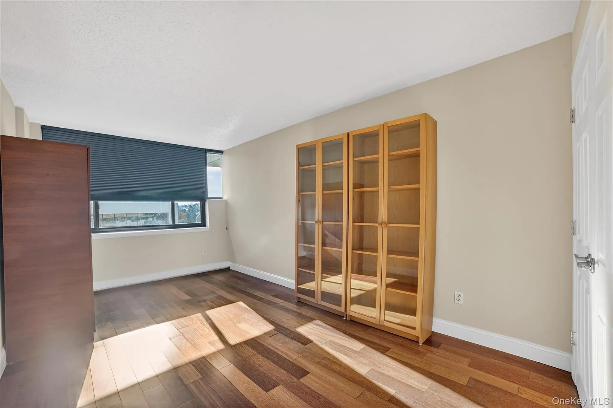 Unfurnished room featuring wood finished floors and baseboards Unfurnished room featuring wood finished floors and baseboards