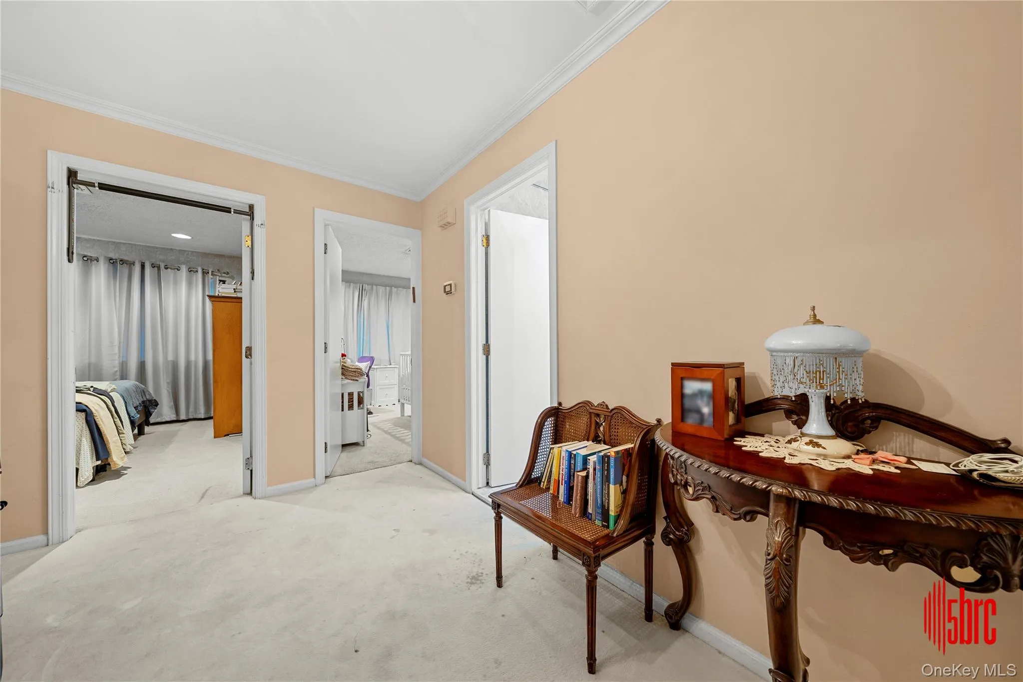 Hallway featuring carpet floors and crown molding Hallway featuring carpet floors and crown molding
