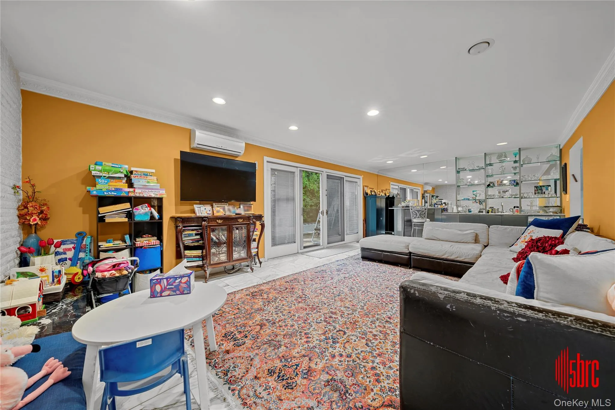 Living room with crown molding, recessed lighting, and a wall unit AC Living room with crown molding, recessed lighting, and a wall unit AC