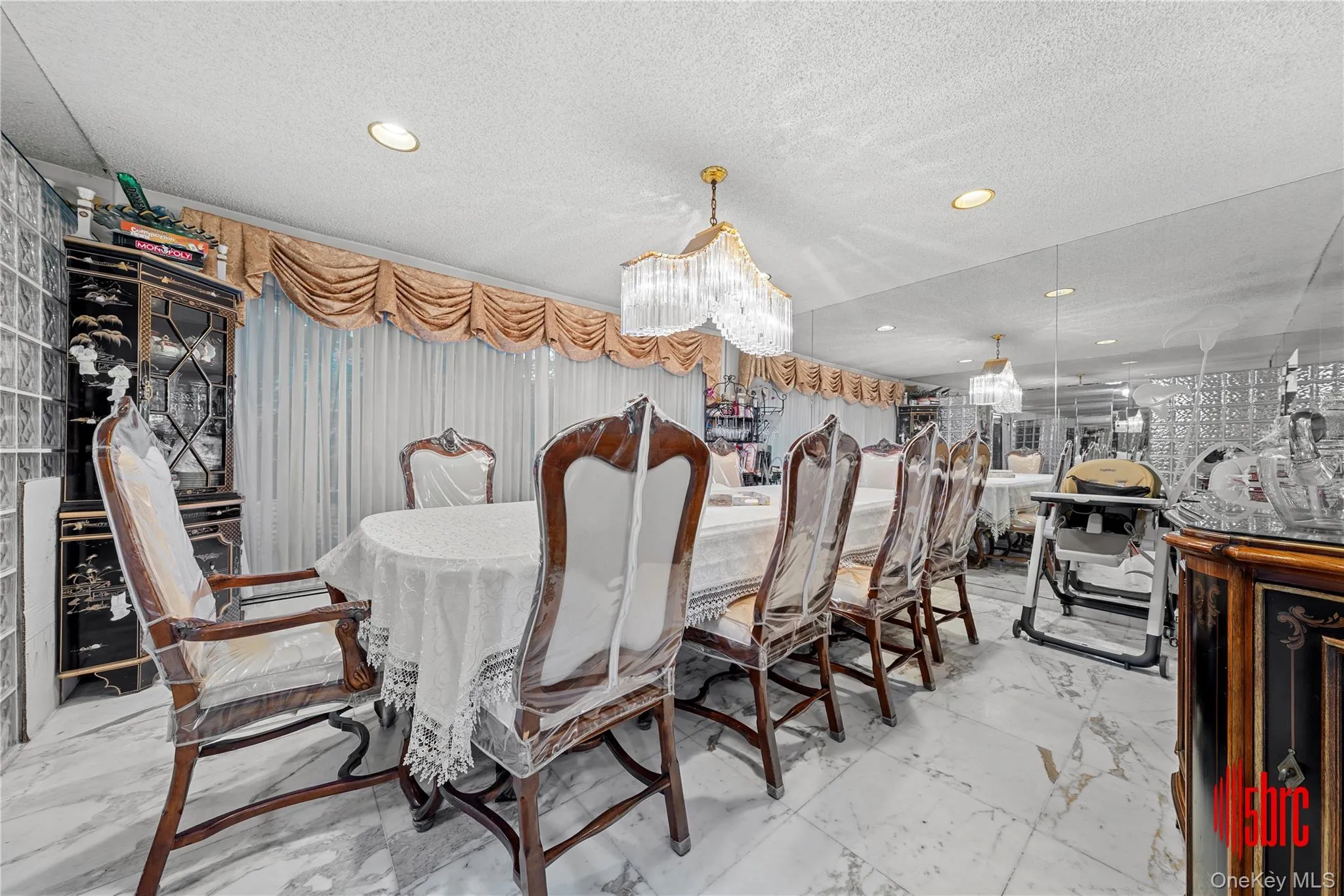 Dining area with light marble finish flooring, a textured ceiling, and recessed lighting Dining area with light marble finish flooring, a textured ceiling, and recessed lighting