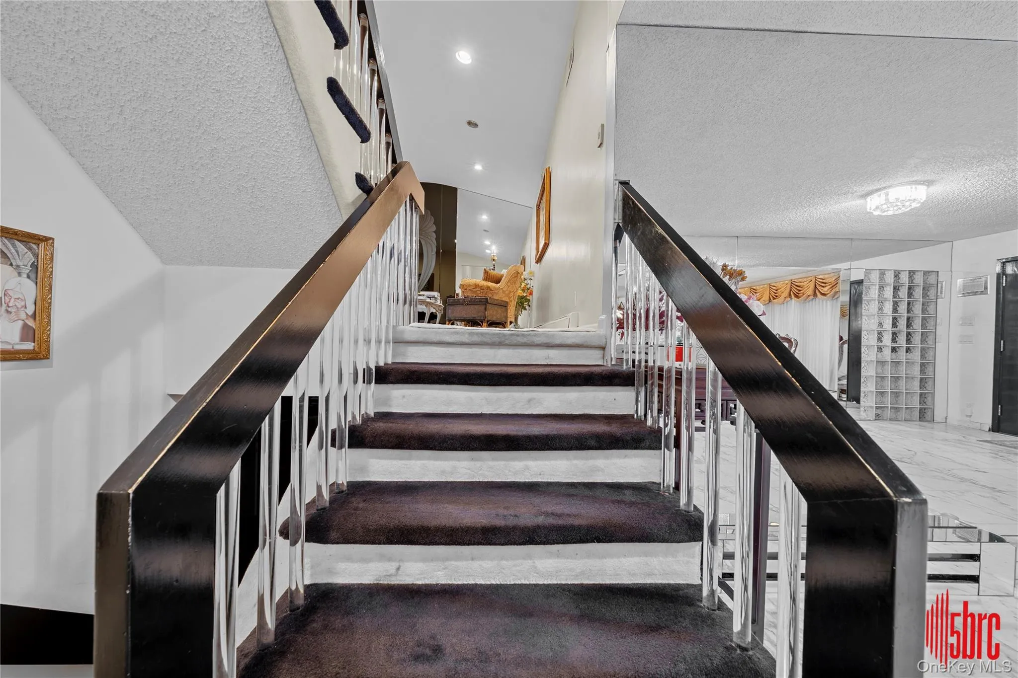Staircase featuring a textured ceiling Staircase featuring a textured ceiling