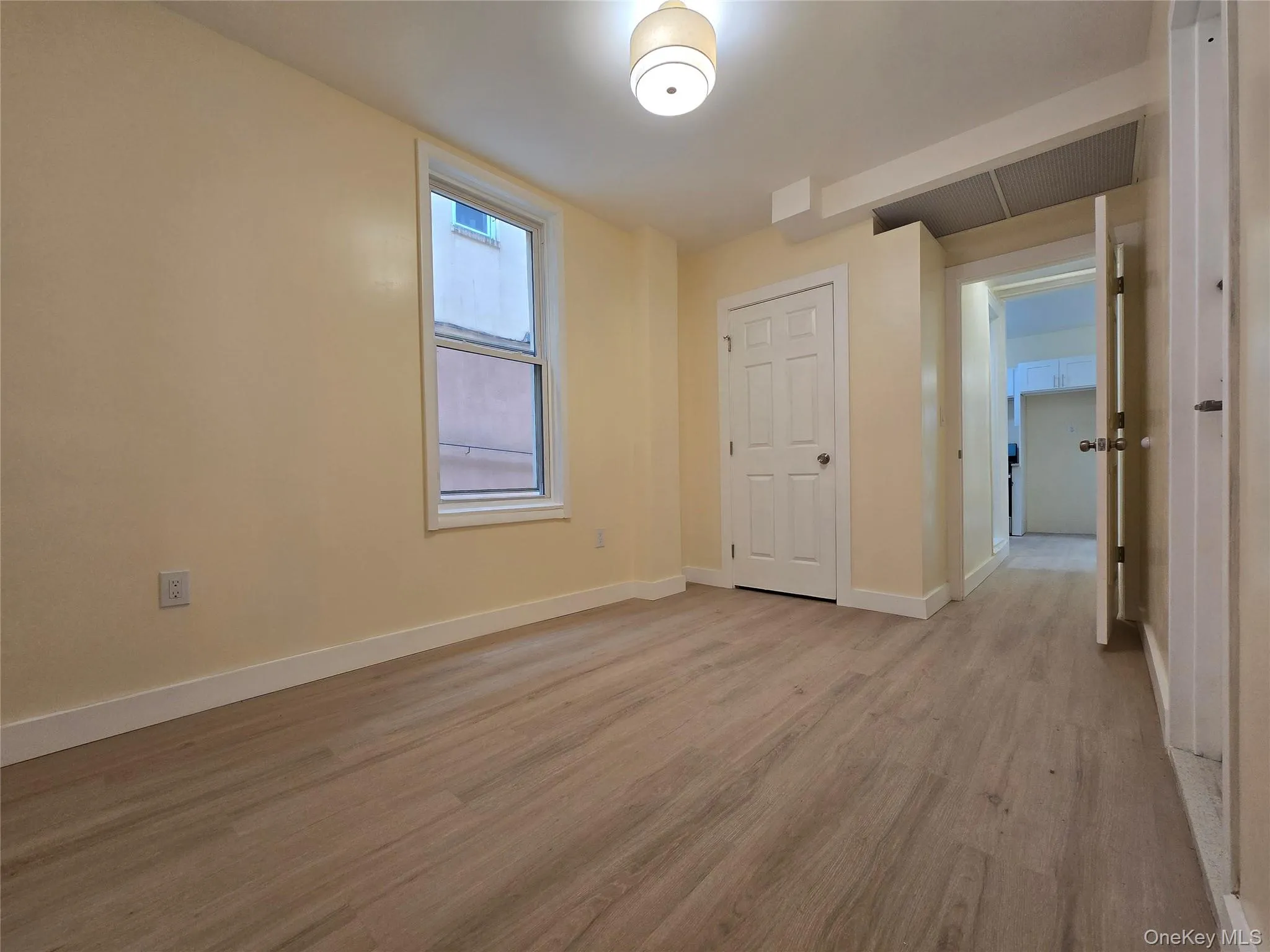 Unfurnished bedroom with light wood finished floors and baseboards Unfurnished bedroom with light wood finished floors and baseboards