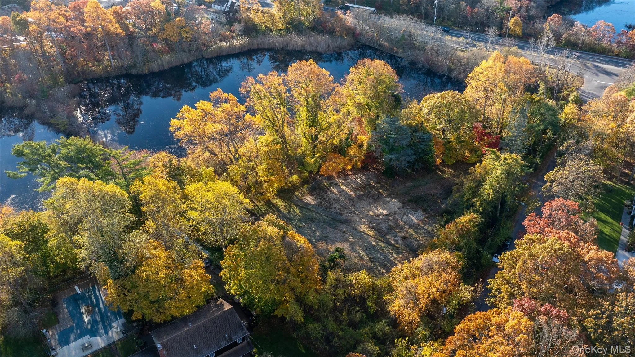 Aerial overview of property's location featuring a large body of water and a heavily wooded area Aerial overview of property's location featuring a large body of water and a heavily wooded area