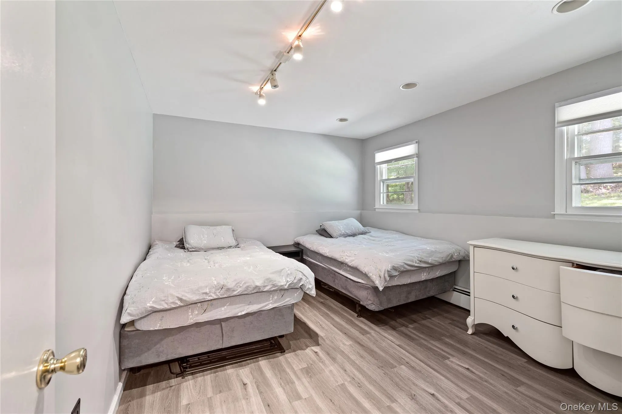Bedroom featuring rail lighting and wood finished floors Bedroom featuring rail lighting and wood finished floors