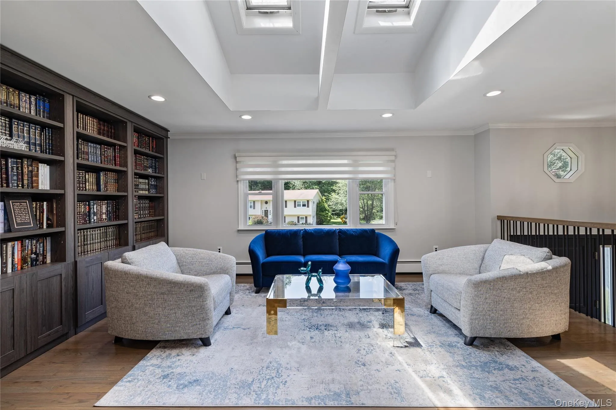 Living room featuring recessed lighting, wood finished floors, ornamental molding, and a baseboard radiator Living room featuring recessed lighting, wood finished floors, ornamental molding, and a baseboard radiator