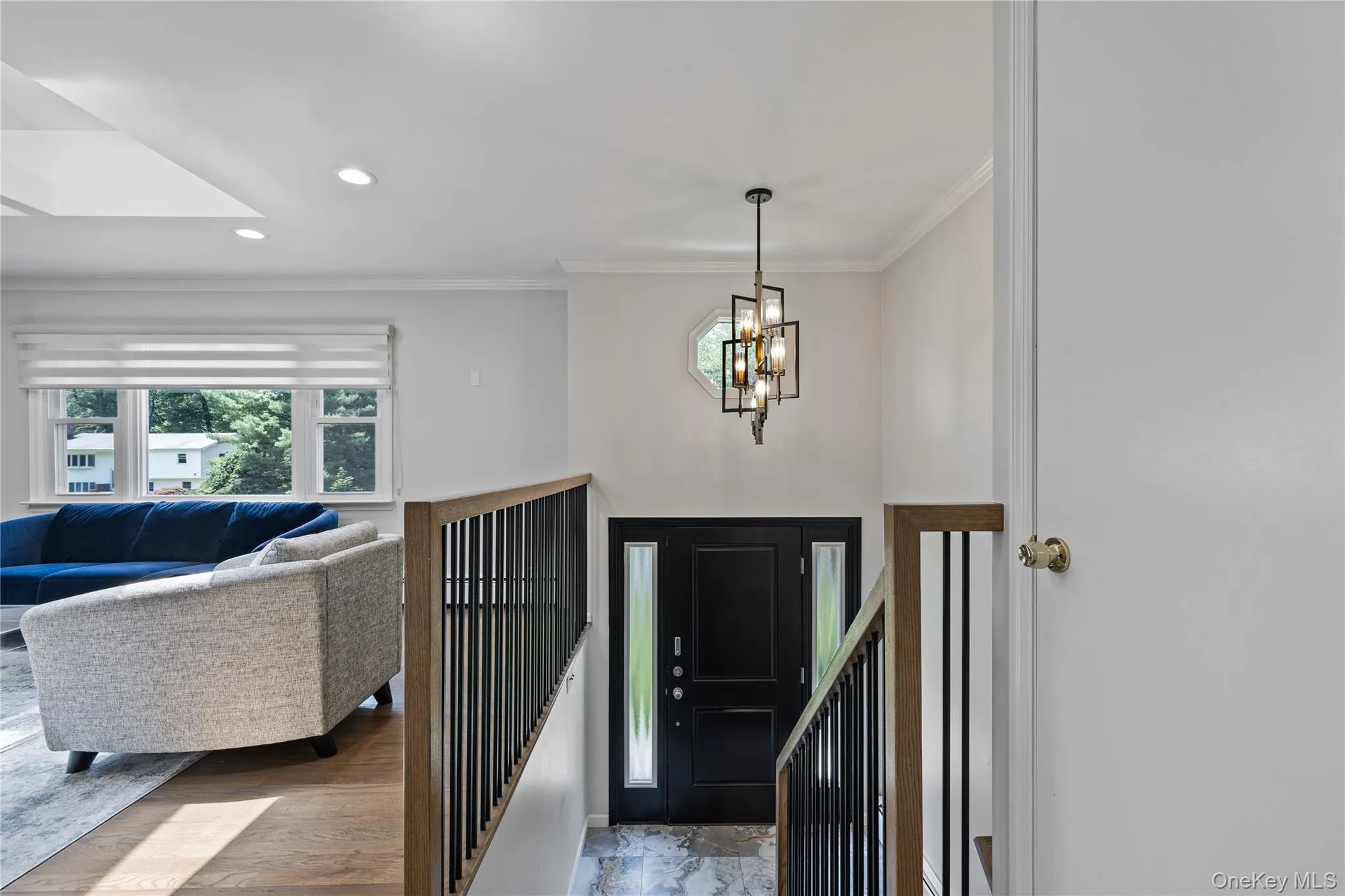 Entrance foyer with ornamental molding, recessed lighting, a chandelier, and wood finished floors Entrance foyer with ornamental molding, recessed lighting, a chandelier, and wood finished floors