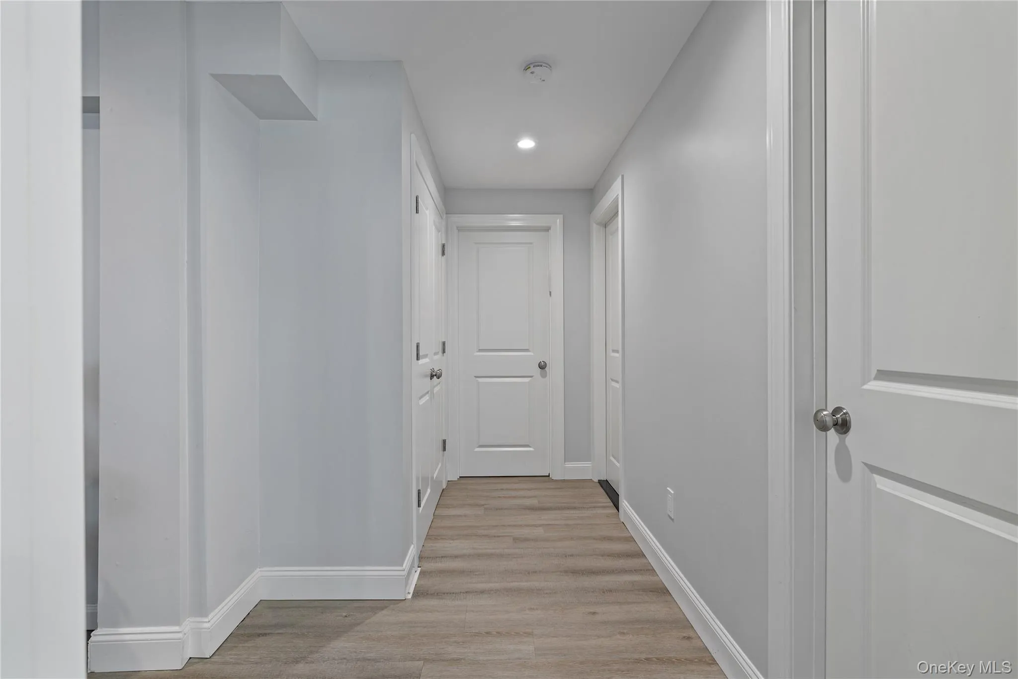 Corridor with light wood-style flooring and recessed lighting Corridor with light wood-style flooring and recessed lighting