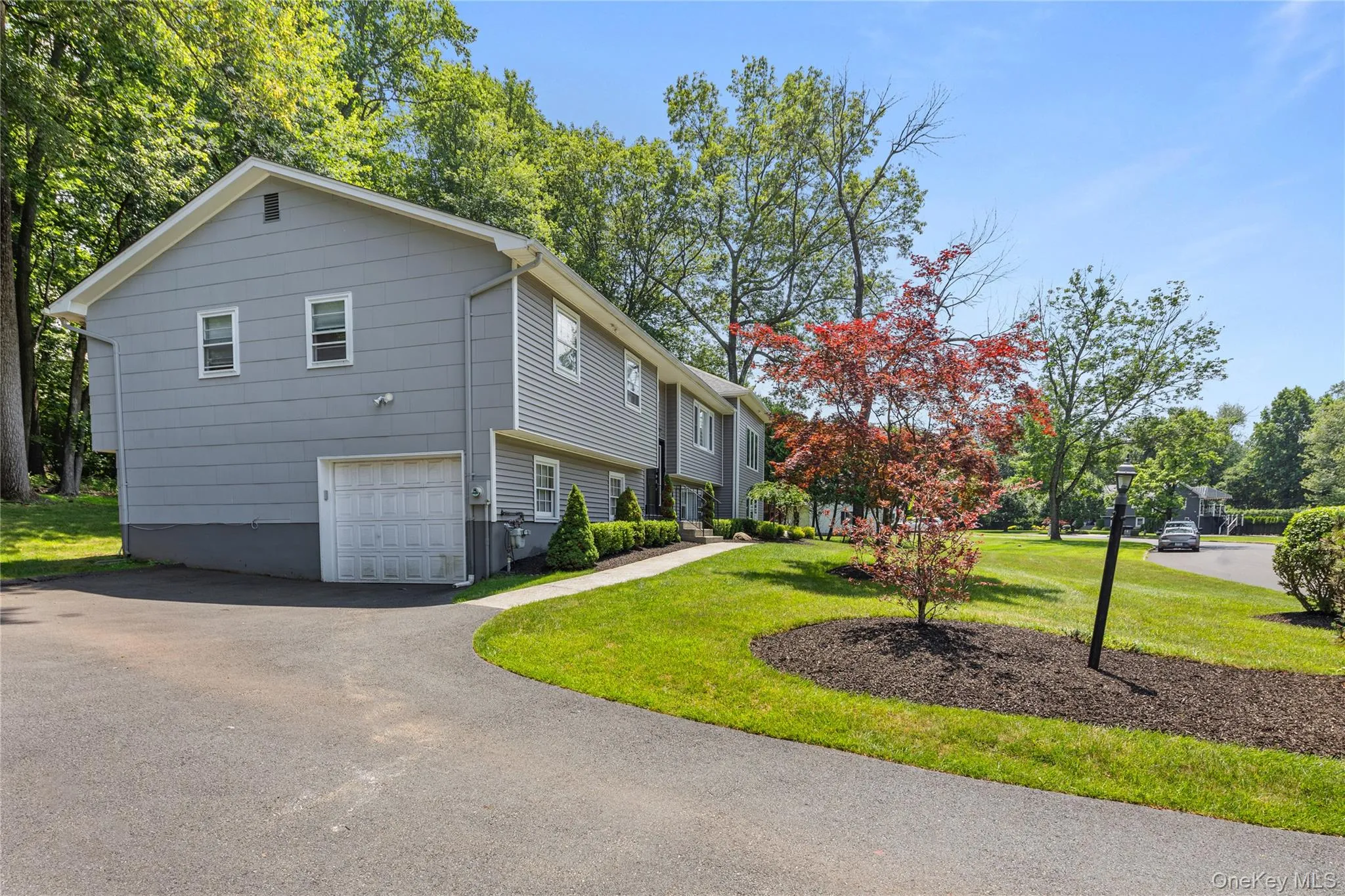 View of property exterior featuring a lawn, a garage, and driveway View of property exterior featuring a lawn, a garage, and driveway