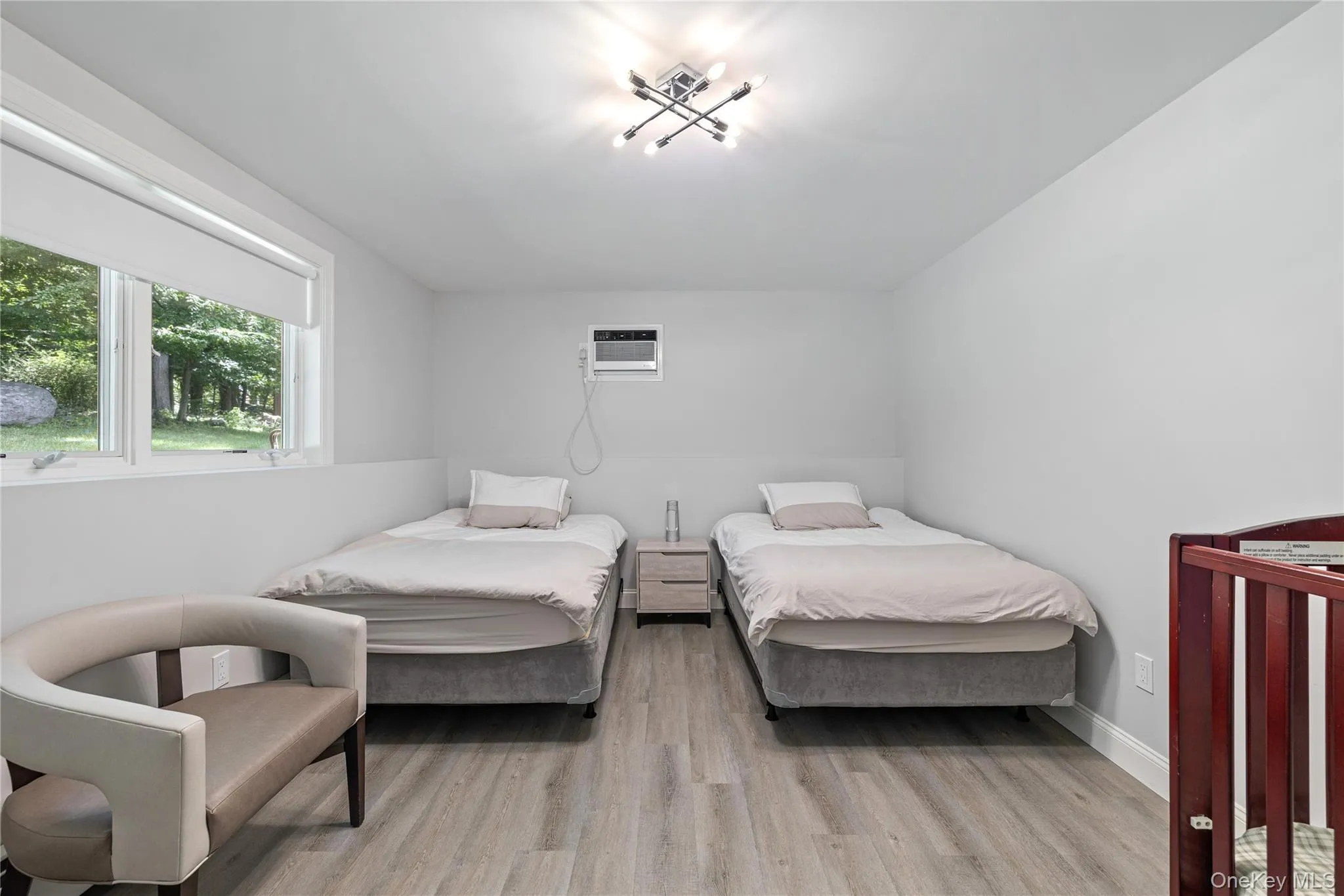 Bedroom with light wood finished floors and a wall unit AC Bedroom with light wood finished floors and a wall unit AC