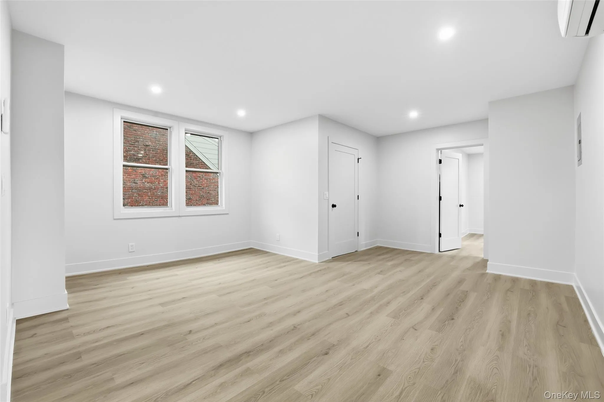 Unfurnished room featuring light wood-style floors, recessed lighting, and a wall unit AC Unfurnished room featuring light wood-style floors, recessed lighting, and a wall unit AC