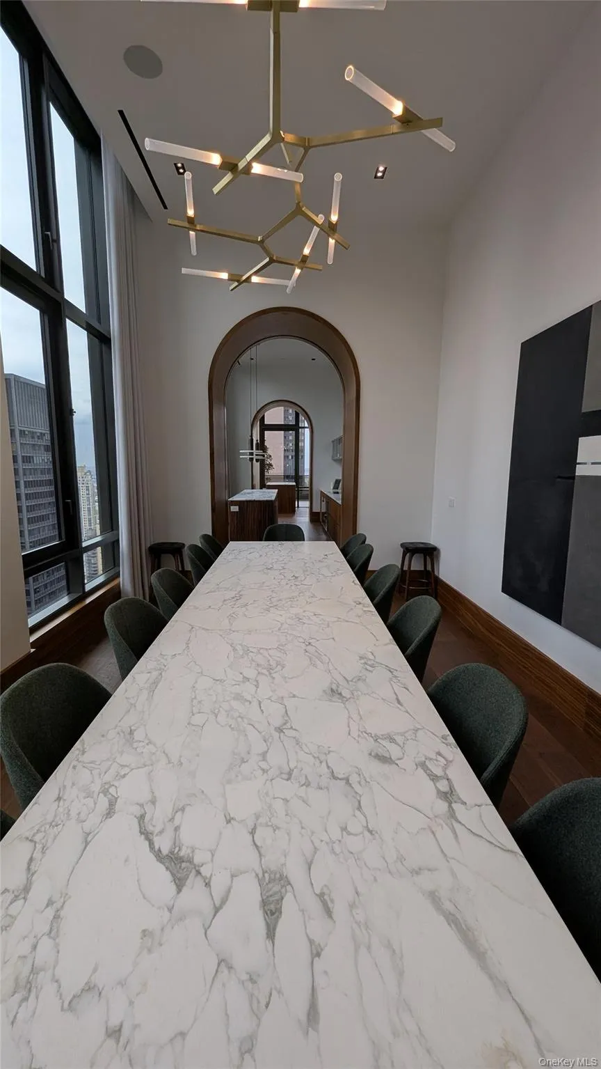 Bedroom featuring a chandelier, arched walkways, and dark wood-style flooring Bedroom featuring a chandelier, arched walkways, and dark wood-style flooring