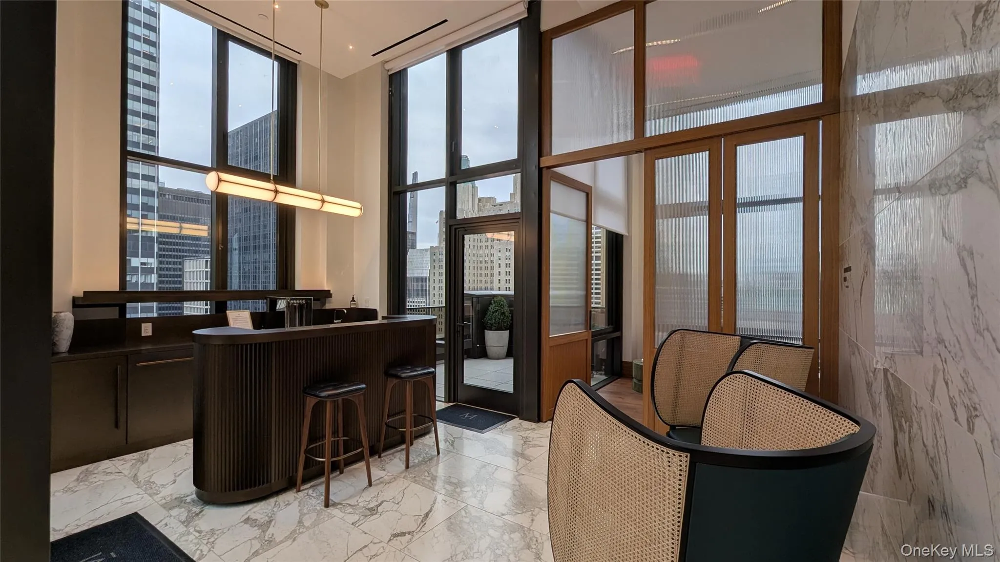 Community bar area featuring a view of city, floor to ceiling windows, dark countertops, decorative light fixtures, and dark brown cabinets Community bar area featuring a view of city, floor to ceiling windows, dark countertops, decorative light fixtures, and dark brown cabinets