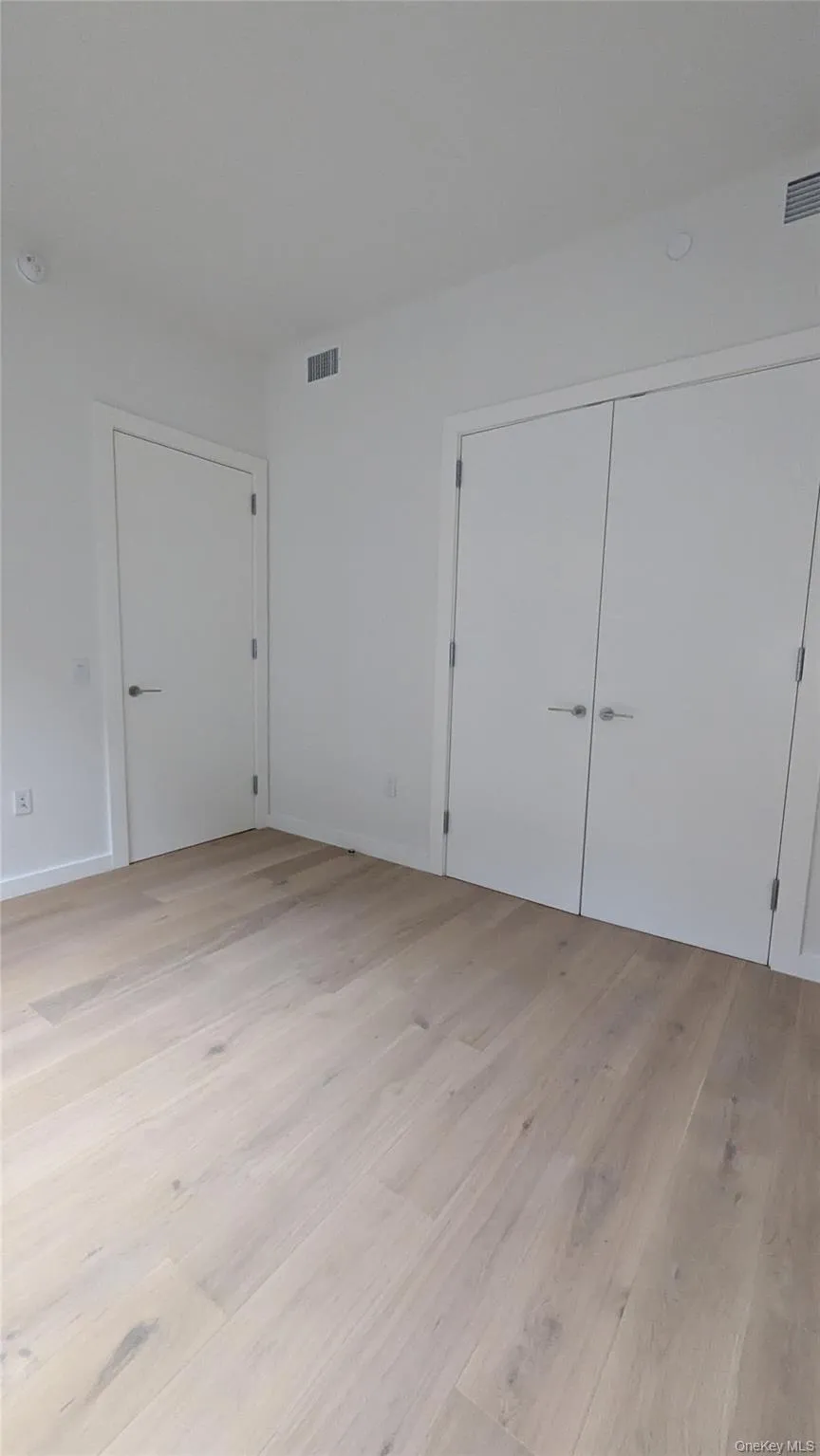 Unfurnished bedroom featuring light wood finished floors and a closet Unfurnished bedroom featuring light wood finished floors and a closet
