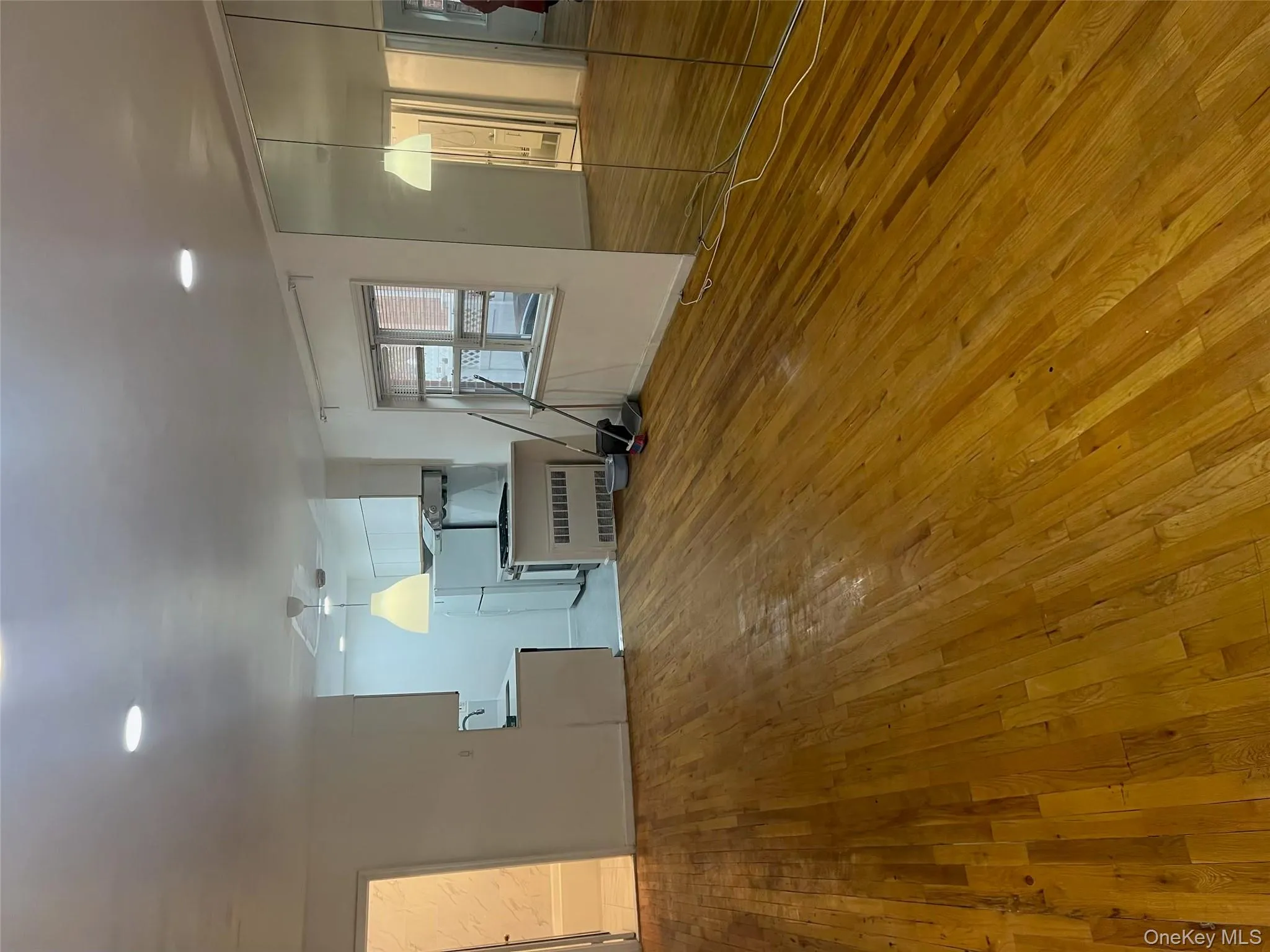 Unfurnished living room featuring light wood finished floors, radiator, and recessed lighting Unfurnished living room featuring light wood finished floors, radiator, and recessed lighting