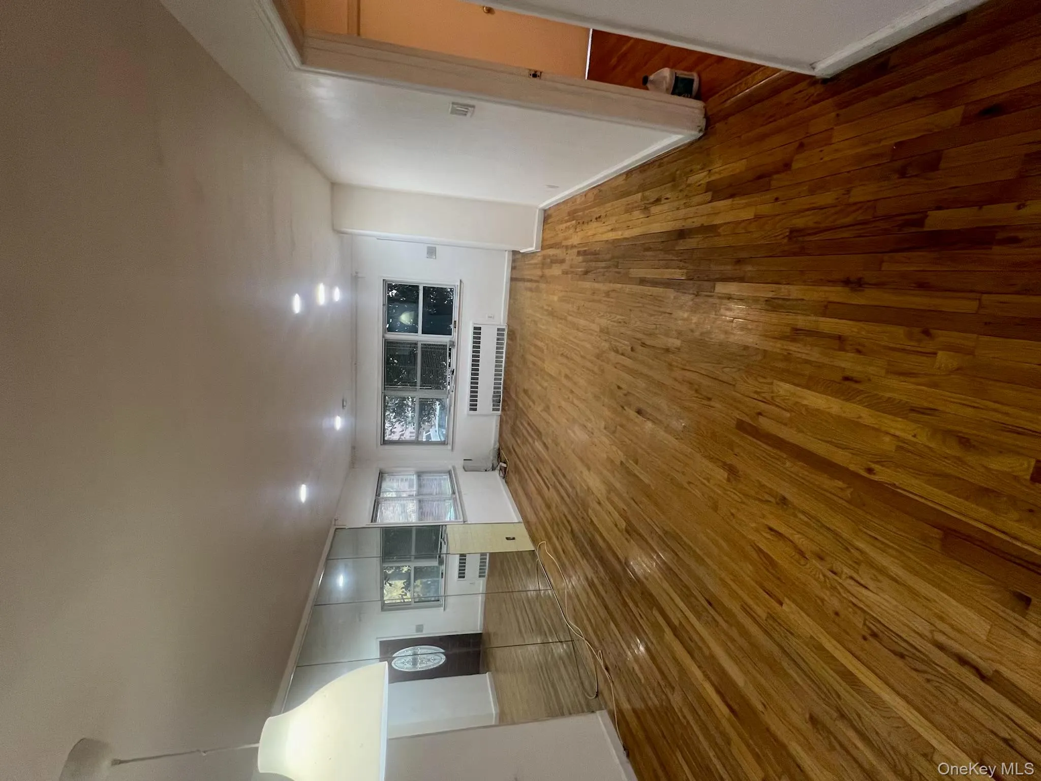 Unfurnished living room featuring hardwood / wood-style floors, recessed lighting, and radiator Unfurnished living room featuring hardwood / wood-style floors, recessed lighting, and radiator